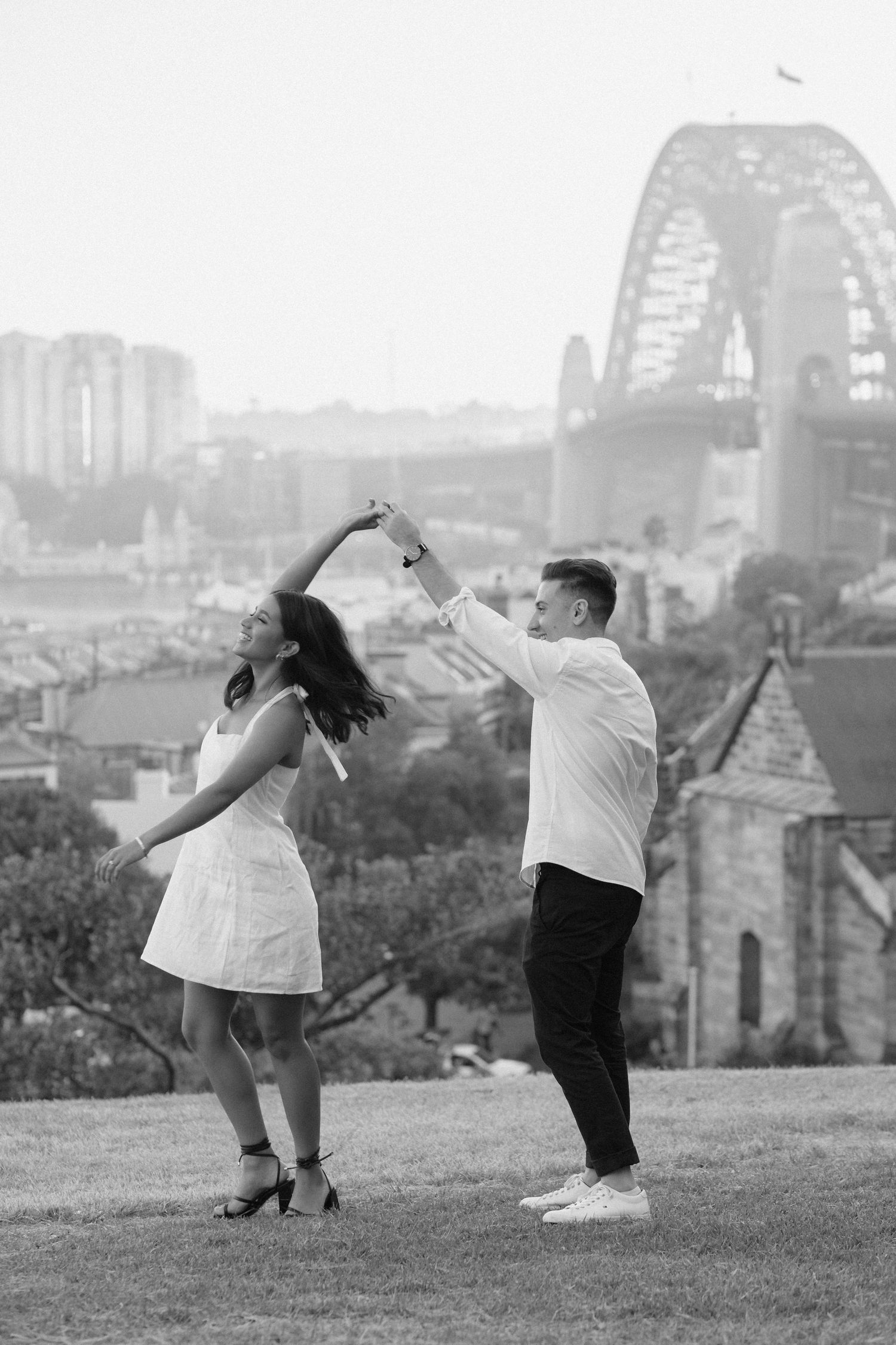 A dancing couple enjoying a moment against the Sydney Harbour Bridge backdrop.