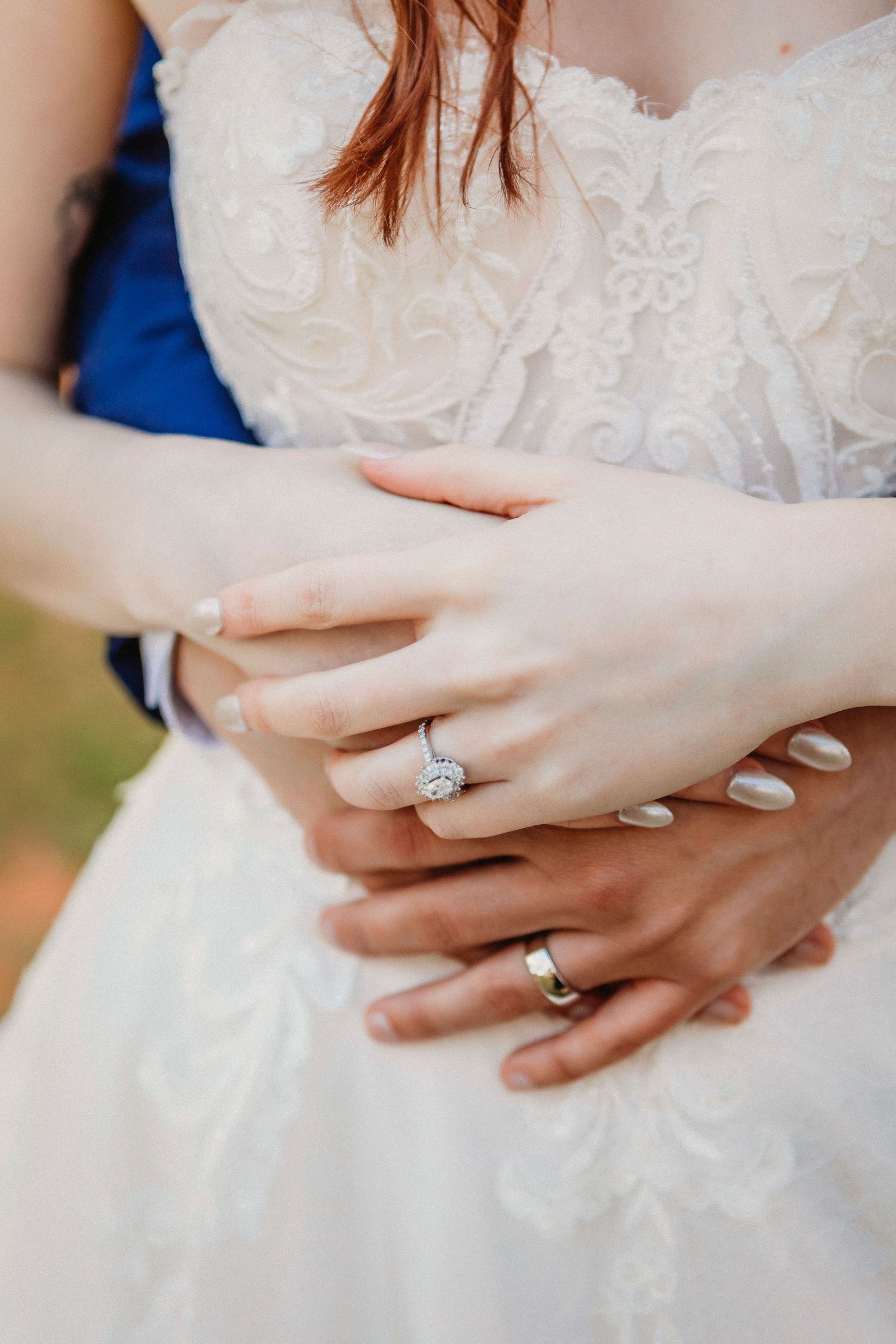 Close-up of bride's hands showing elegant diamond engagement ring and wedding band.