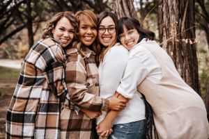 Group embracing and laughing together during casual outdoor fall family photo session.
