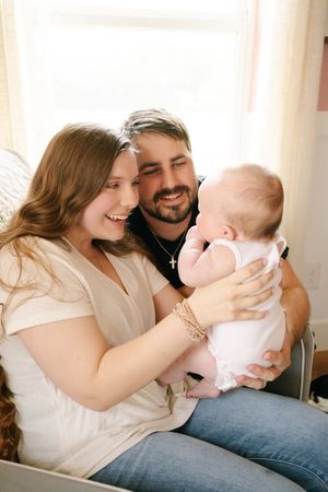 Parents share loving moments with their baby while relaxing at home.