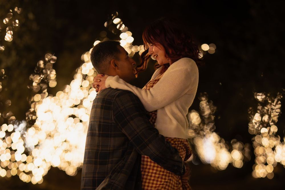 A couple dances together in a romantic sunset setting with golden light filtering through trees.