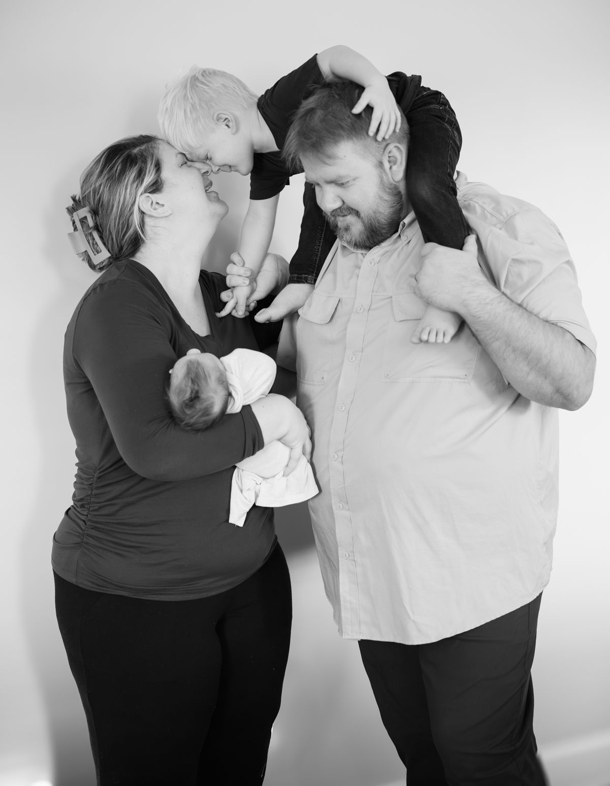 Black and white intimate family portrait showing tender moment together.