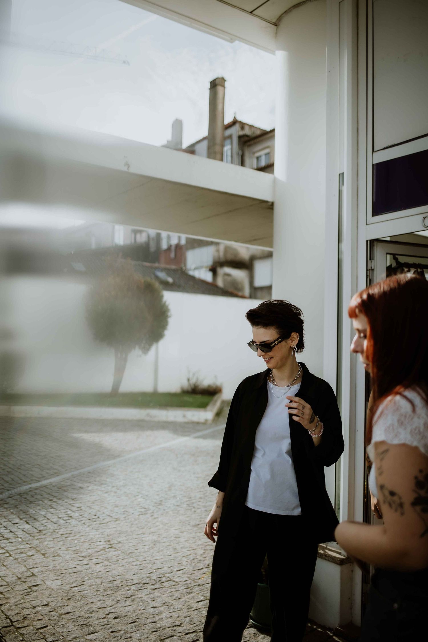 People conversing near windows with foggy outdoor view.