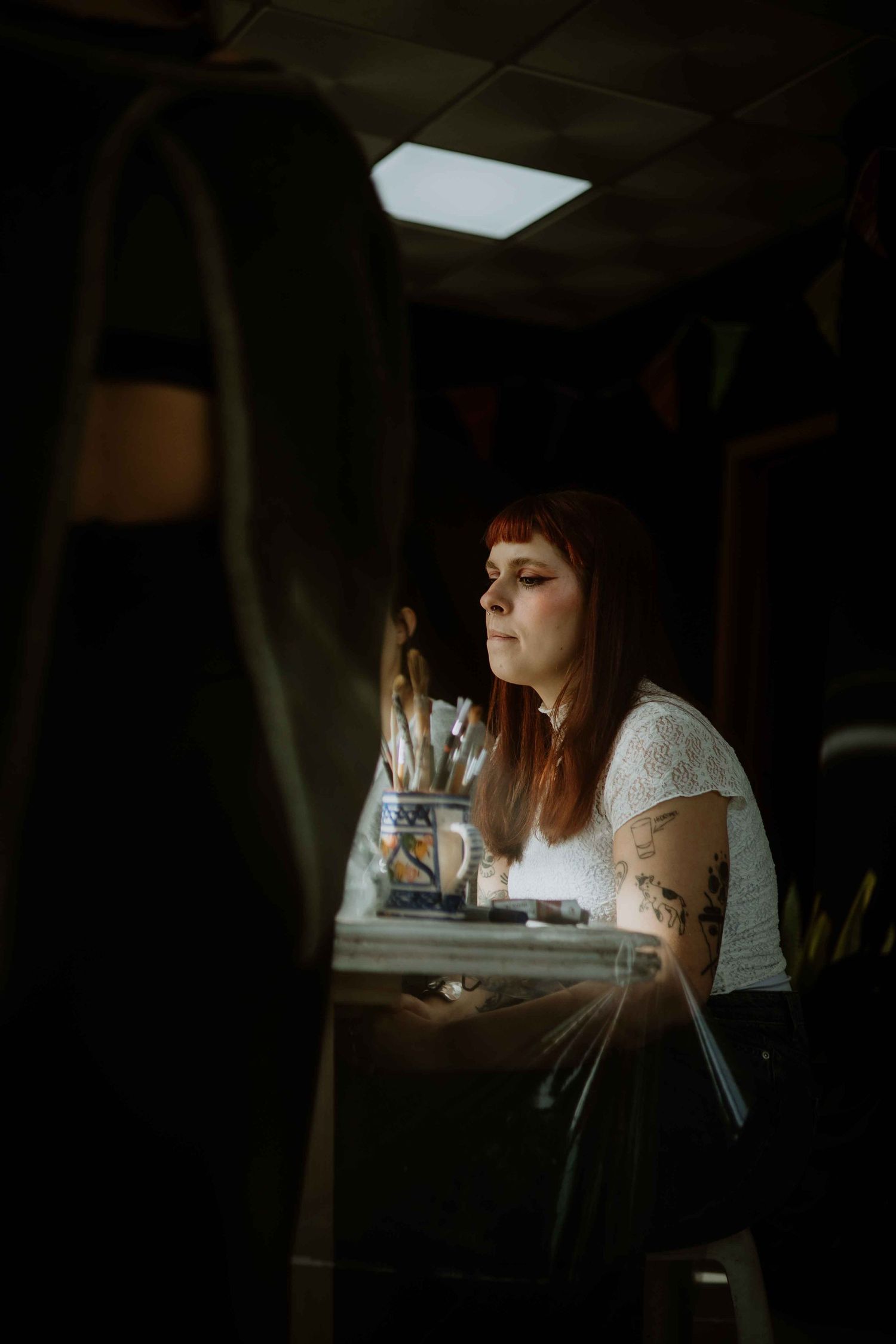Person working at a dimly lit desk with a bright light source.