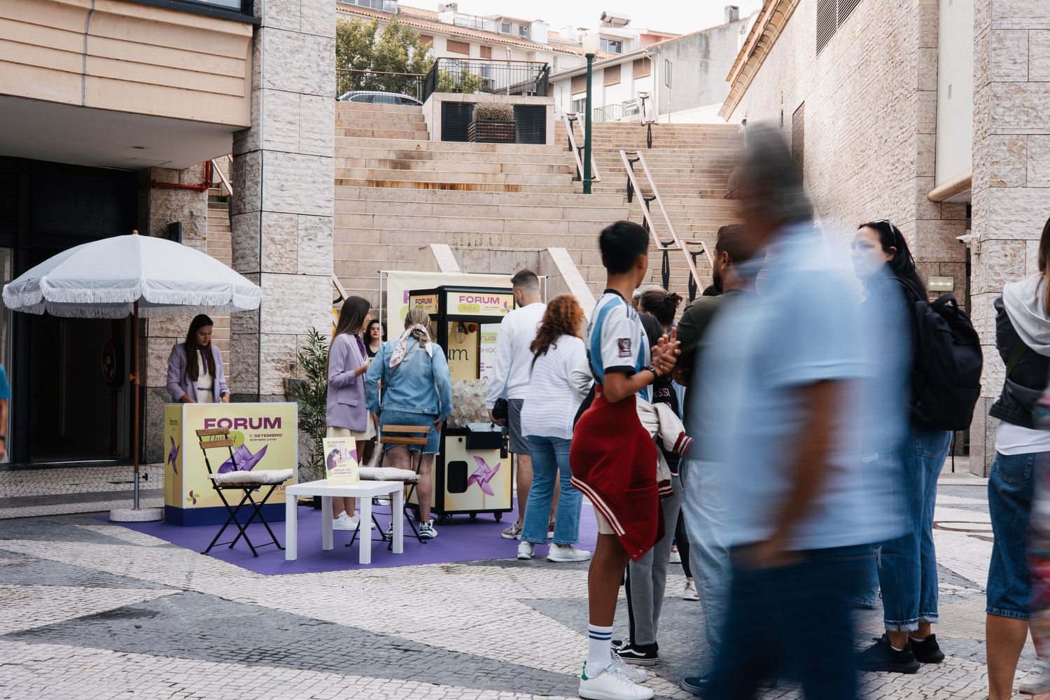 Fotografia de movimento no fórum aveiro, turistas desfocados a percorrer um corredor de pedra.
