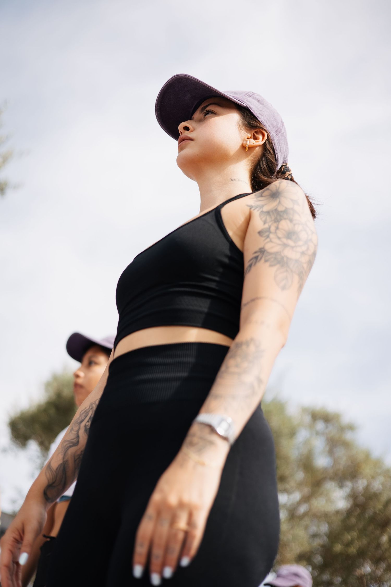 Sessão de fitness ao ar livre com céu nublado — força, atitude e estilo em tons de preto.