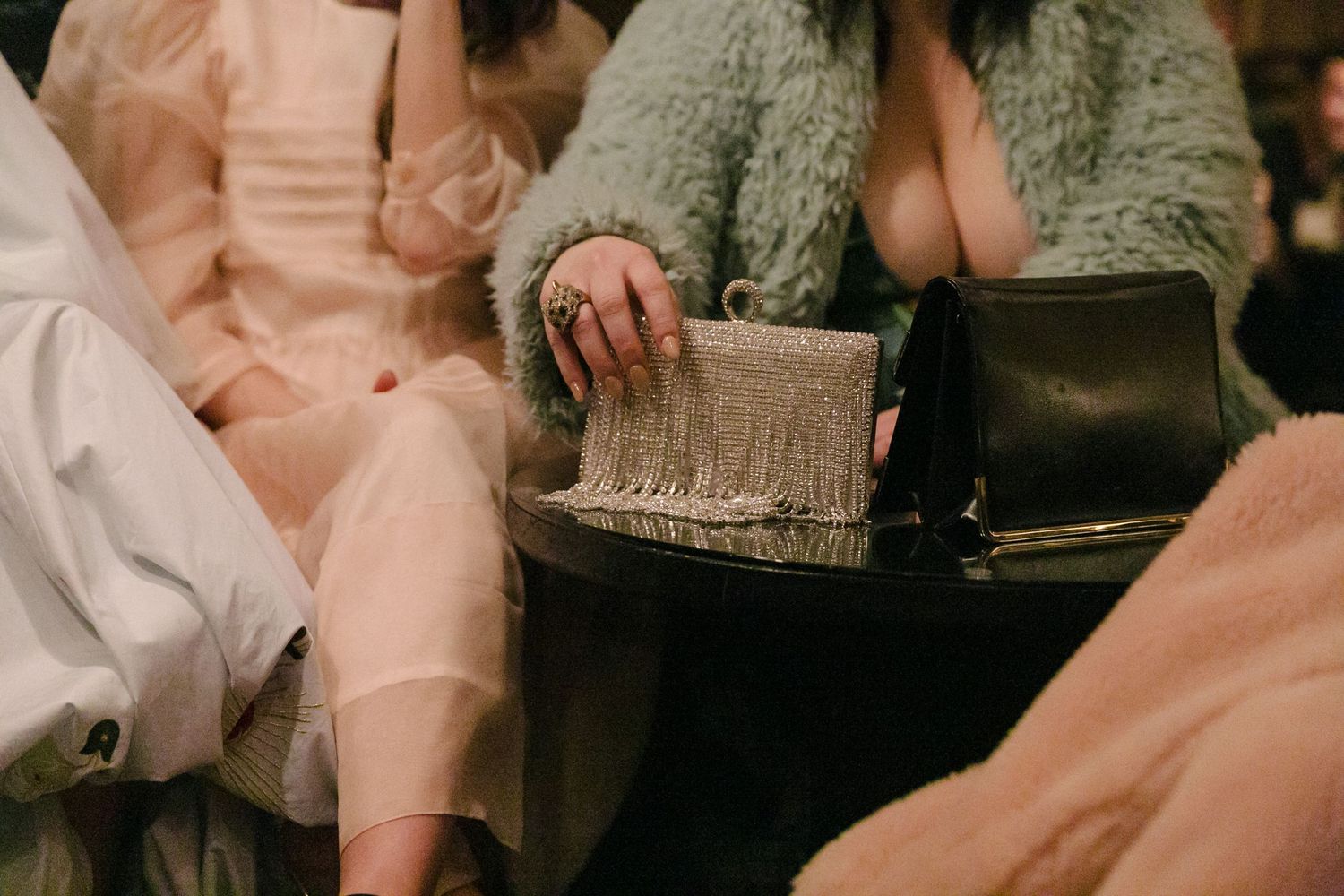 Two people in cozy loungewear sit together while browsing through a vintage photo album.