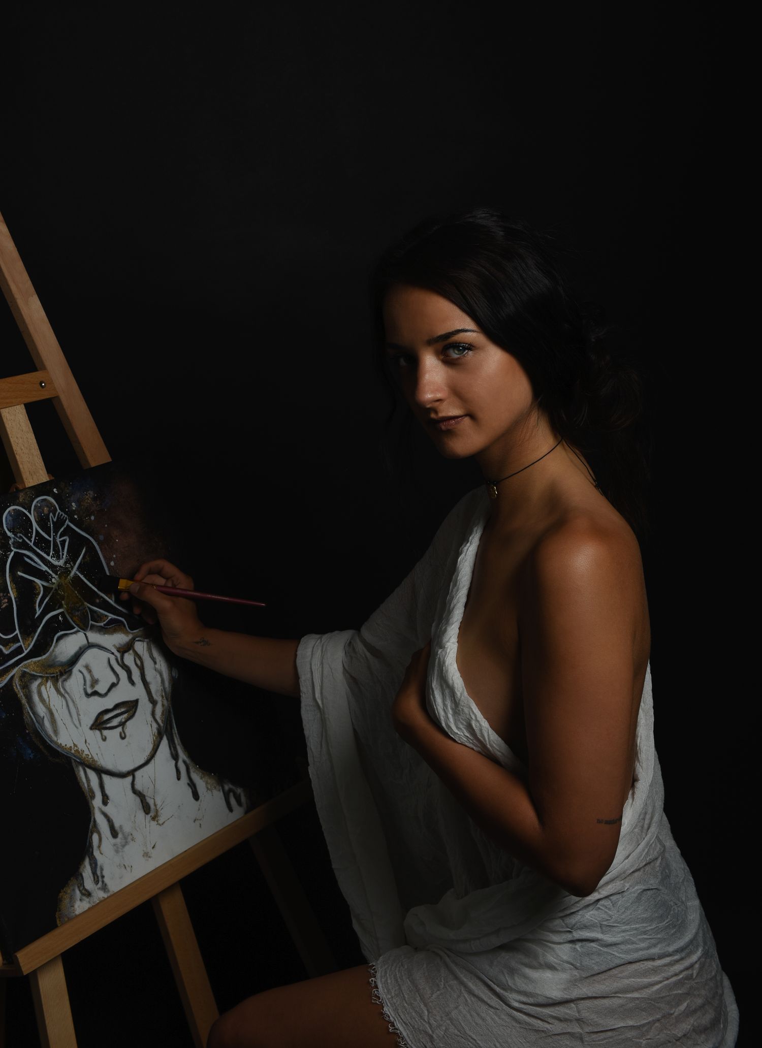 Fine Art Fotografie - Artist works on black and white portrait sketch in dramatic low-key lighting.