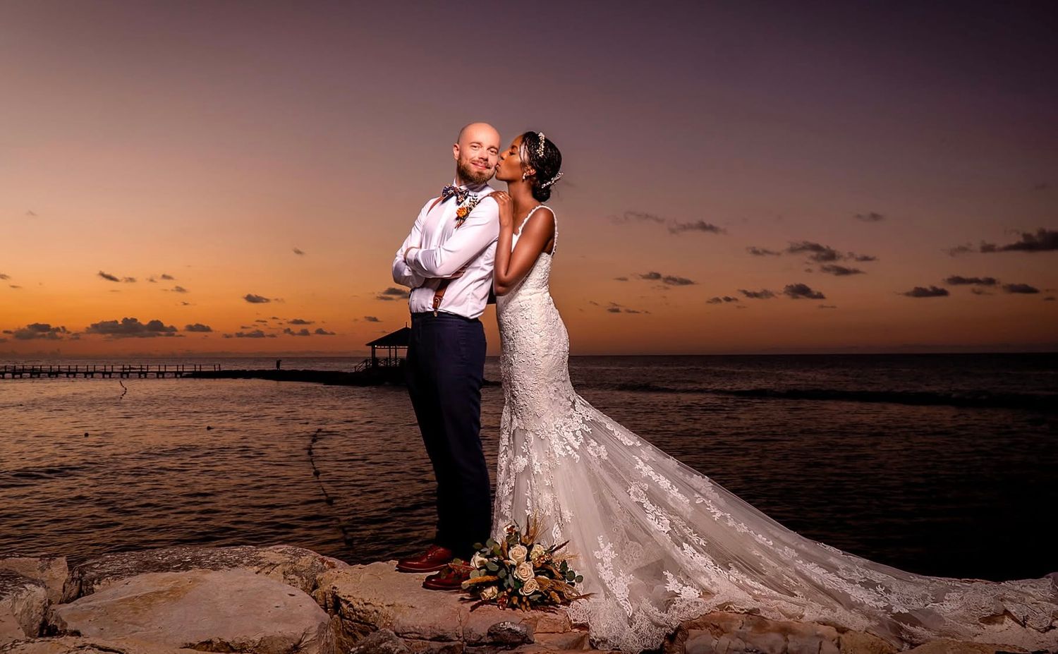 Dramatic sunset beach wedding portraits with flowing white dress.