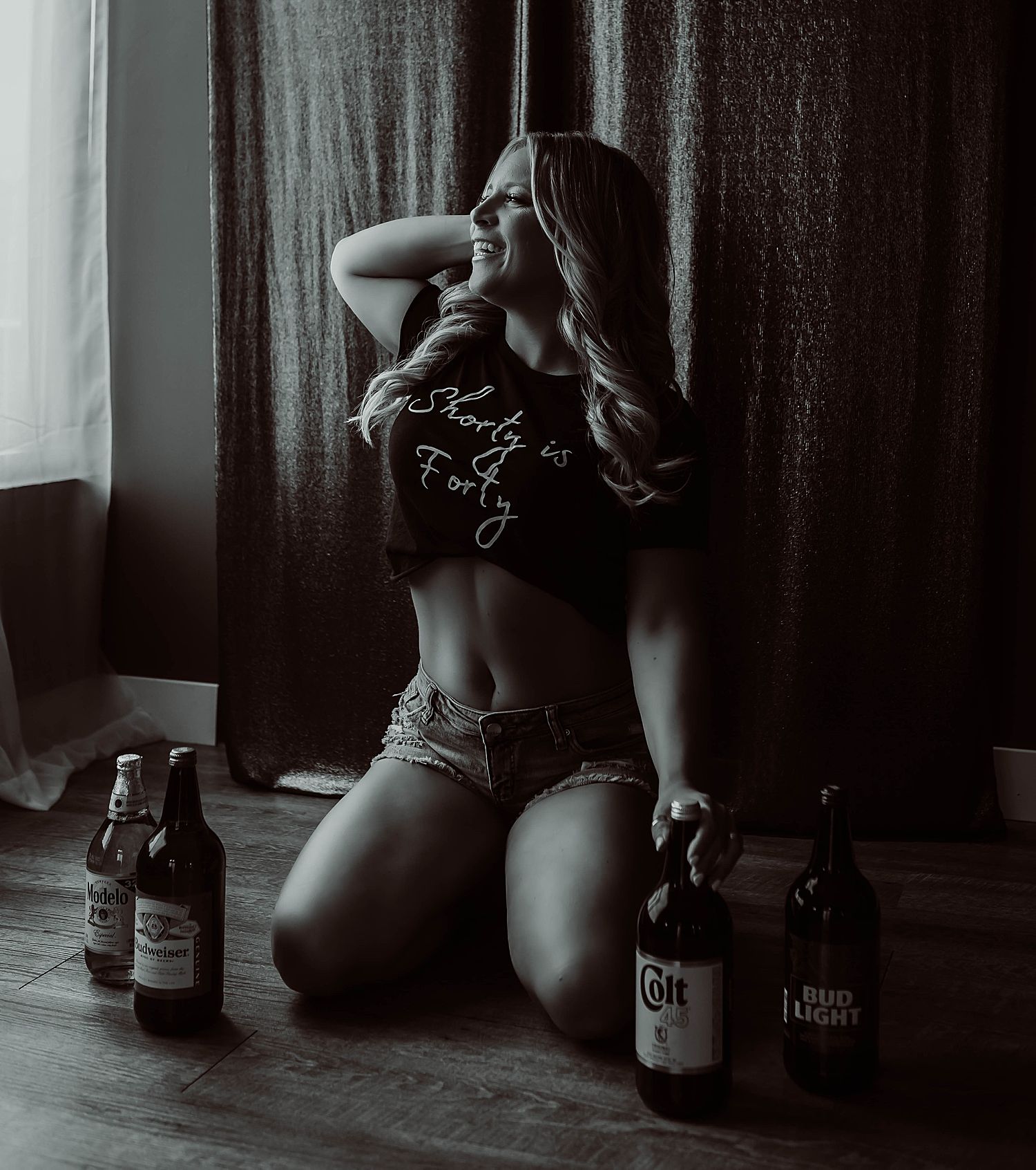 woman kneels on the floor in jeans and crop top by KJ Boudoir Photography