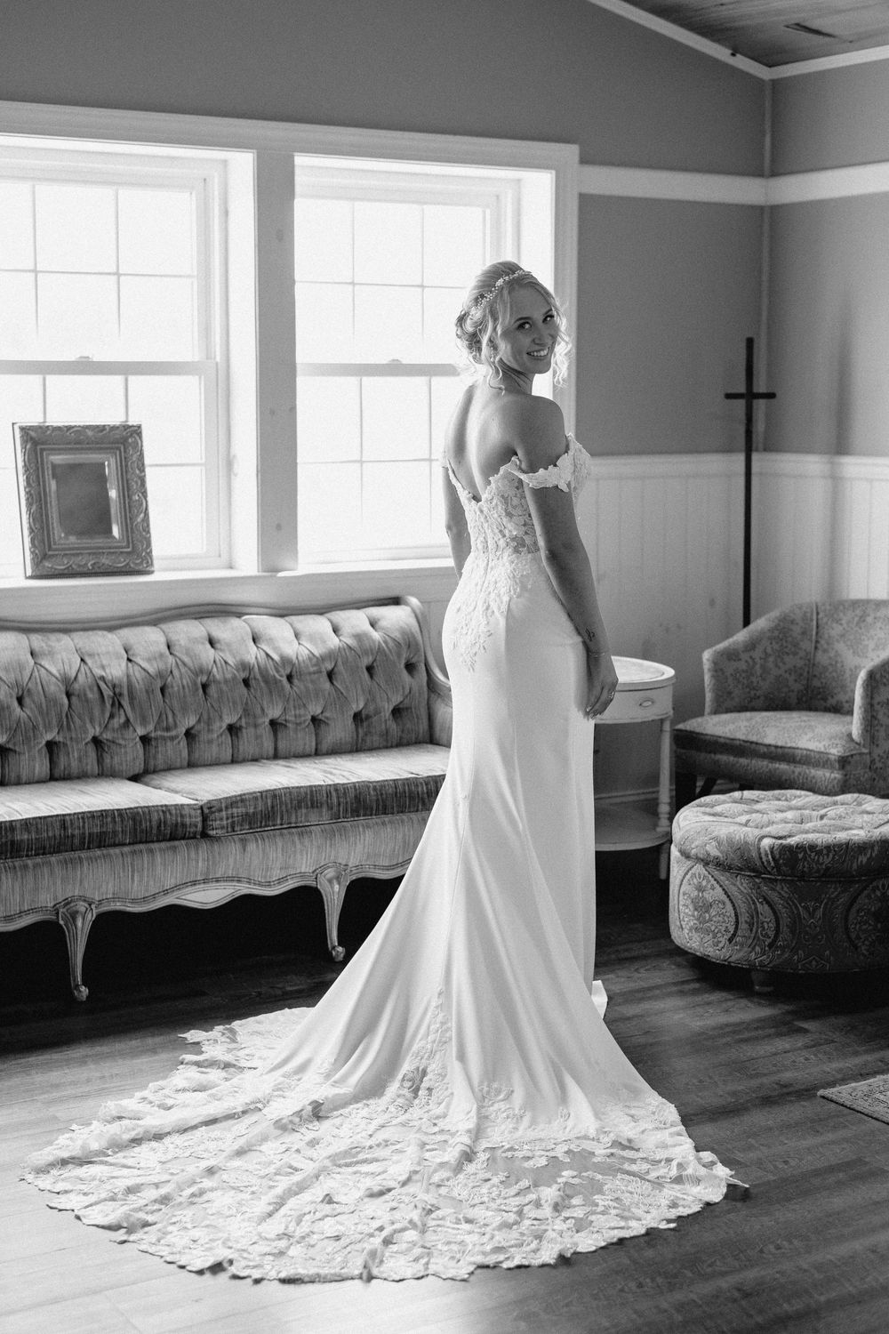 Black and white photos show a bride in a lace wedding dress with a dramatic train against vintage style seating.