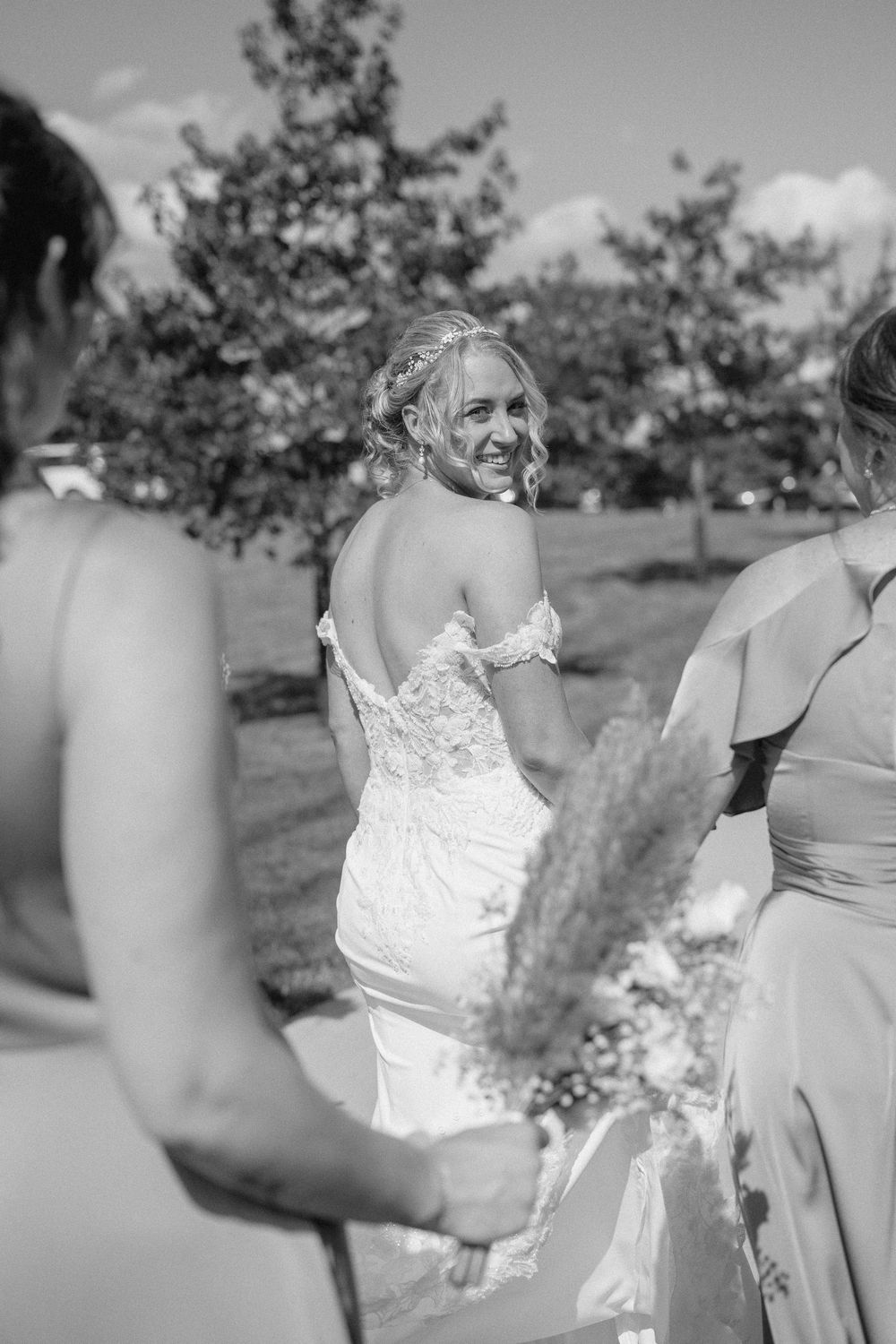 Wedding party in black and white standing outdoors during a summer celebration.