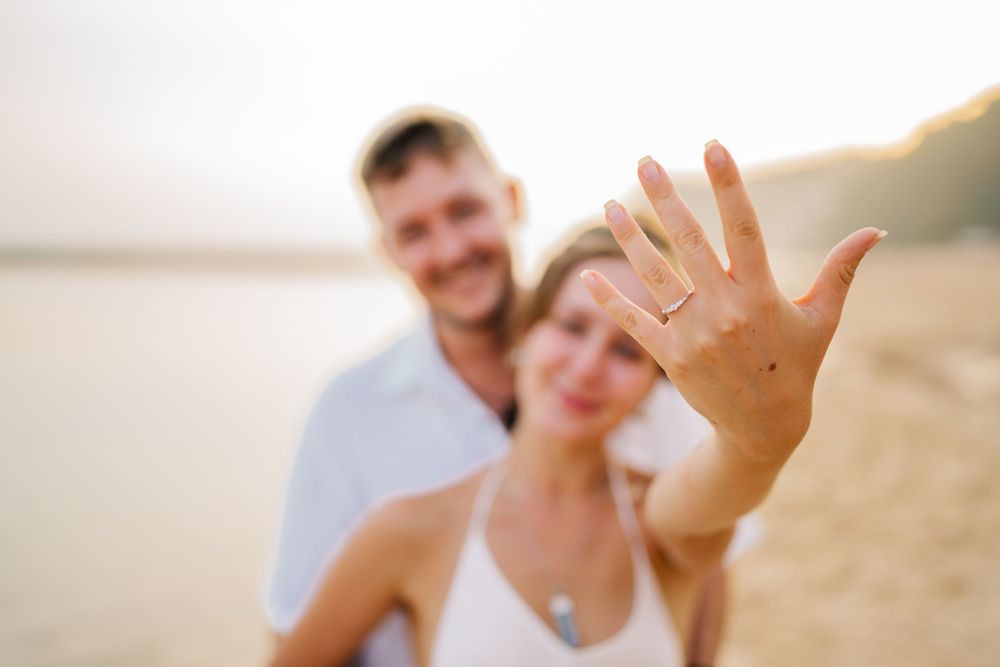Romantic couple sharing intimate moments during a golden hour beach photoshoot.