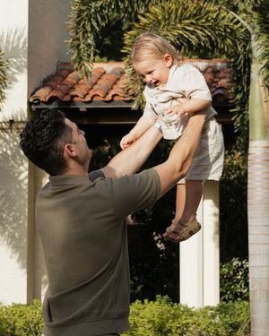 Playful moment captured in a garden setting with joyful expressions.