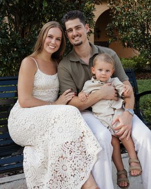 Family wearing white sits together on garden bench for casual outdoor portraits.