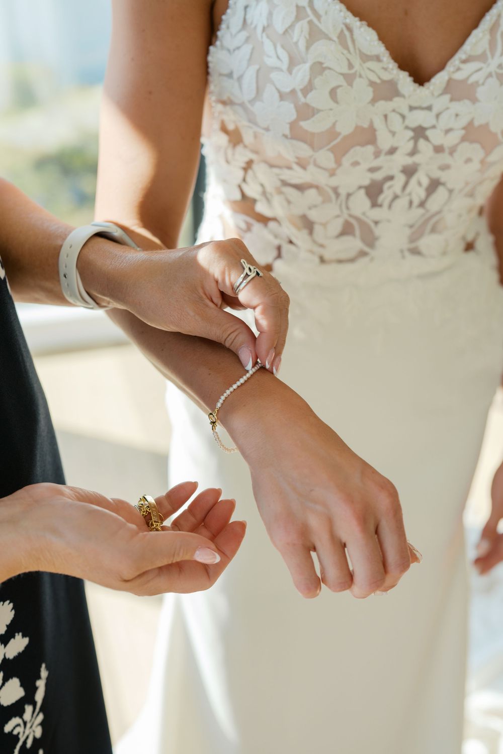 Multiple images showing delicate details of a bride adjusting jewelry while wearing a white lace dress.