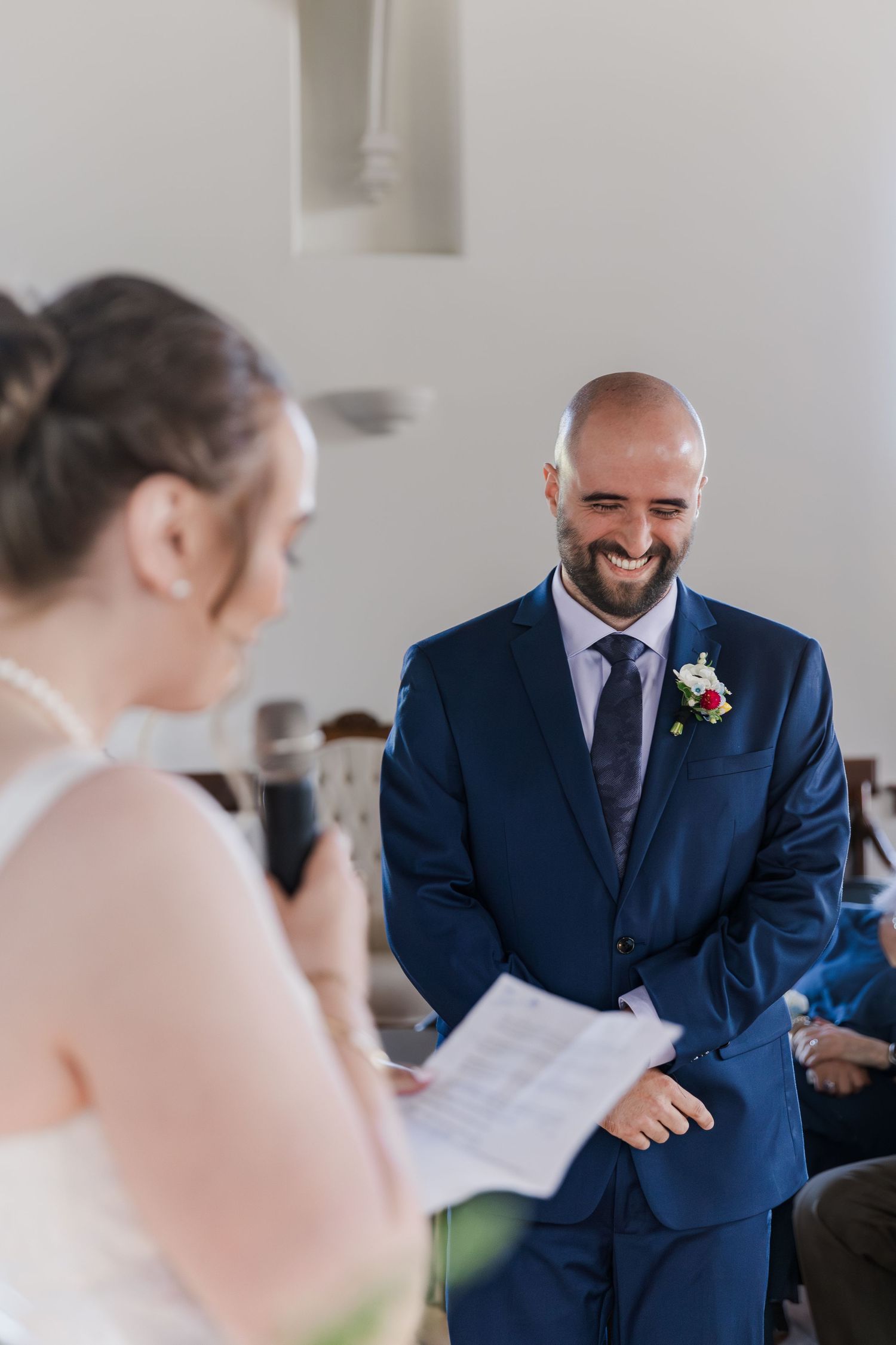 Emotional reactions during wedding vows ceremony in an elegant white chapel setting at Hauser Hall in Kitchener, Ontario.