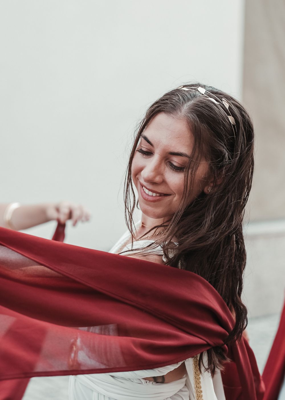 Person in flowing red fabric creating dynamic movement against white background.