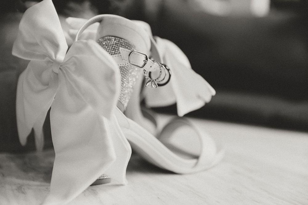 Black and white image of white satin bow details on wedding accessories.