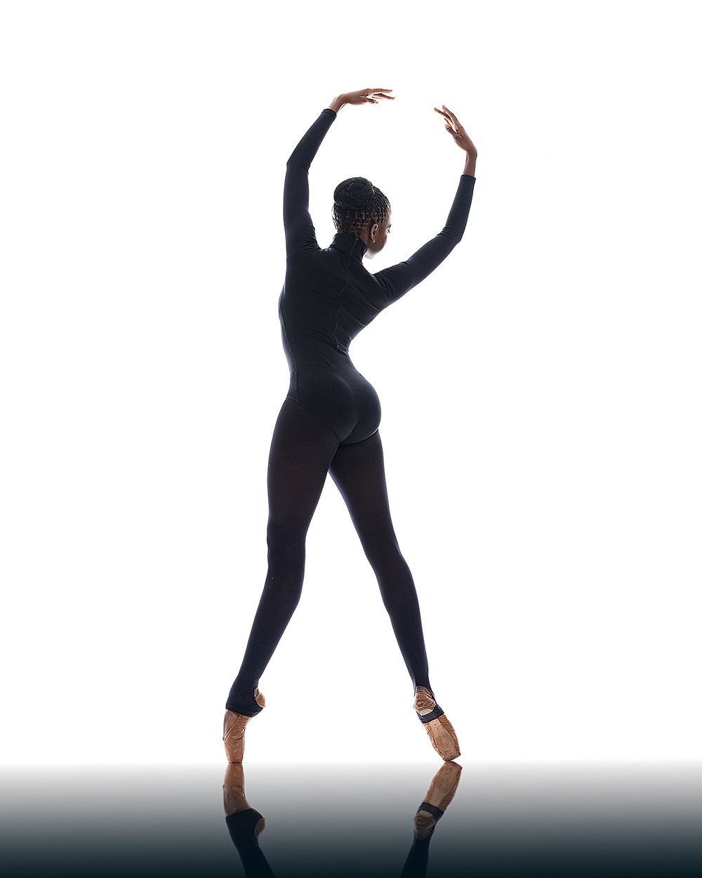 Silhouette of ballet dancers practicing various dance poses and movements against a light background.