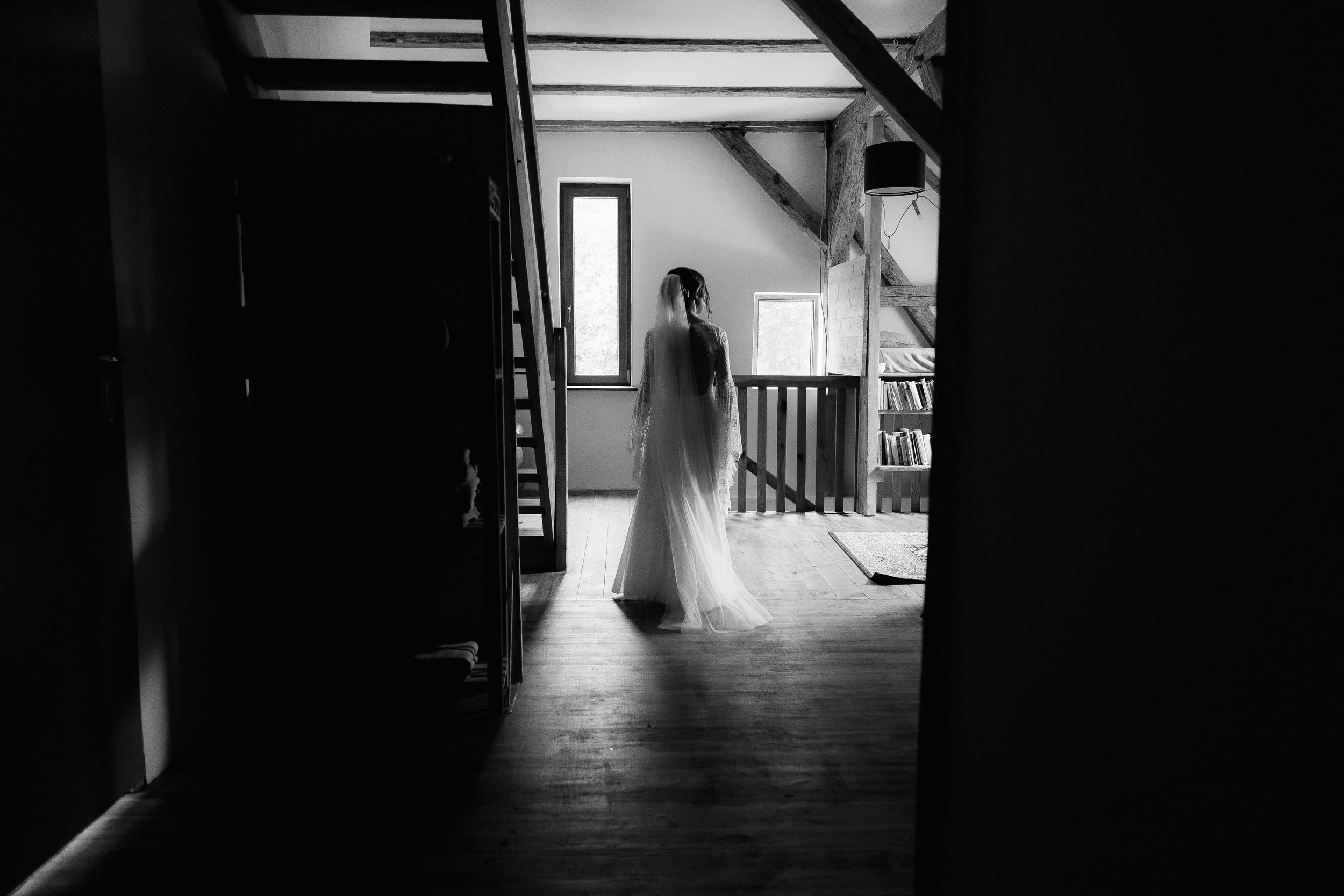 A dark moody hallway with silhouettes and dramatic shadows creates an eerie film noir atmosphere.