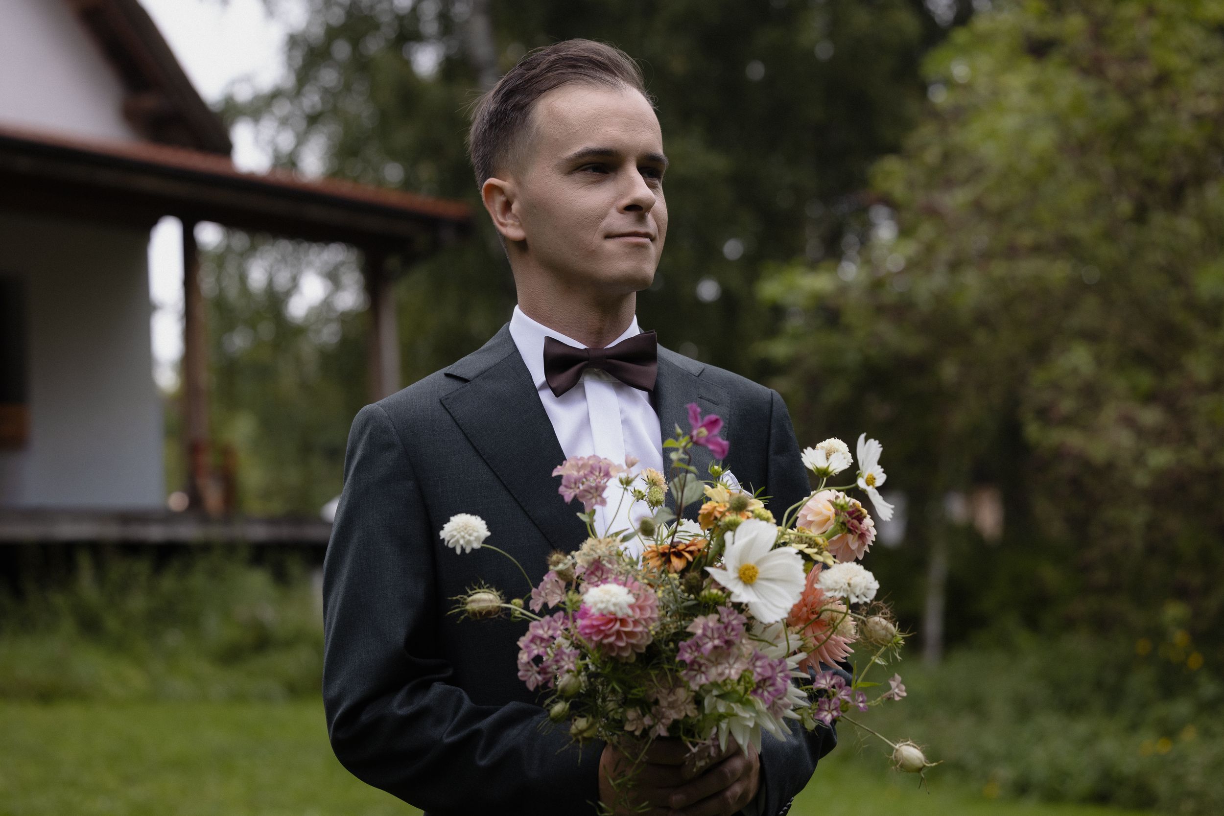 Wedding celebration outdoors shows formal attire and floral décor at a natural outdoor venue.