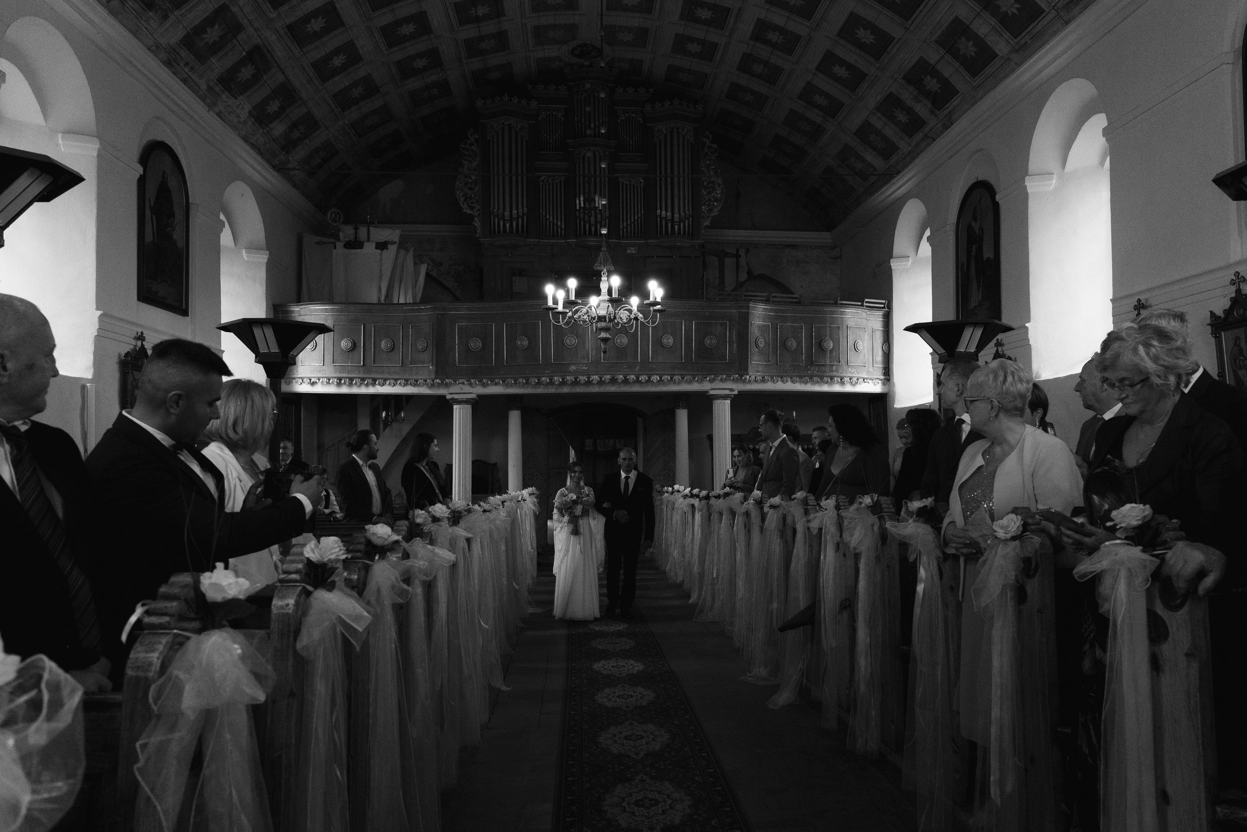 Black and white panoramic image showing a stately historic church sanctuary with arched ceilings and ornate details.