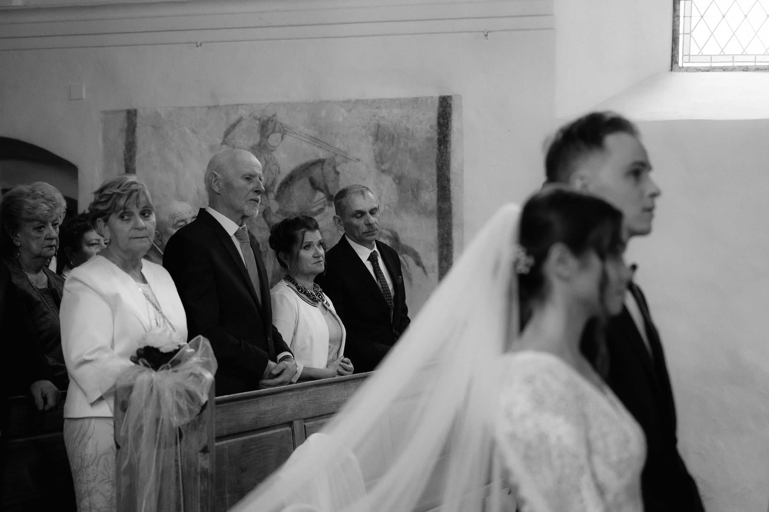 A sequence of black and white photos capturing different moments from a traditional church wedding ceremony.