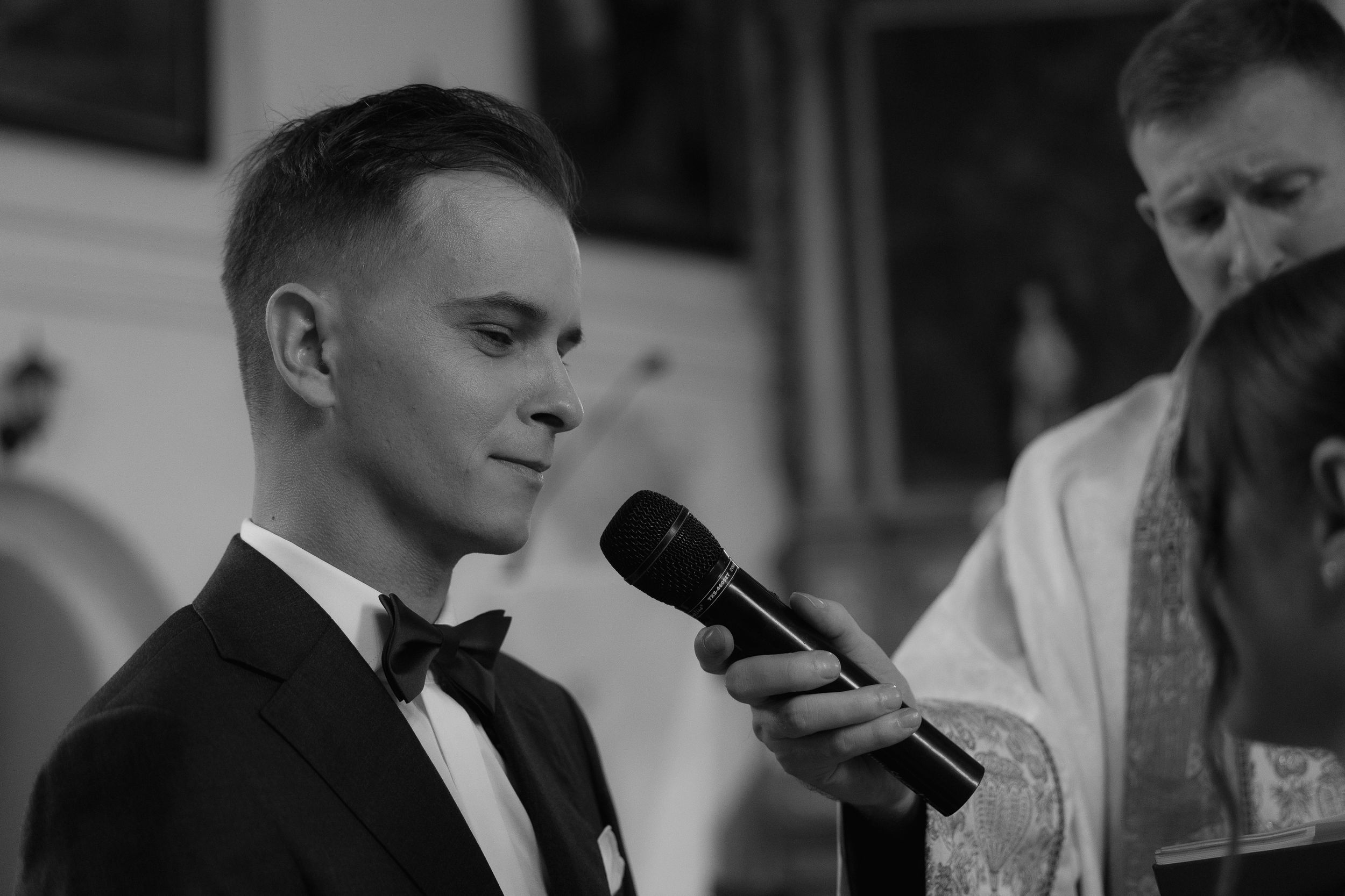 A black and white series of close-up photos showing a person speaking into microphones during a presentation.