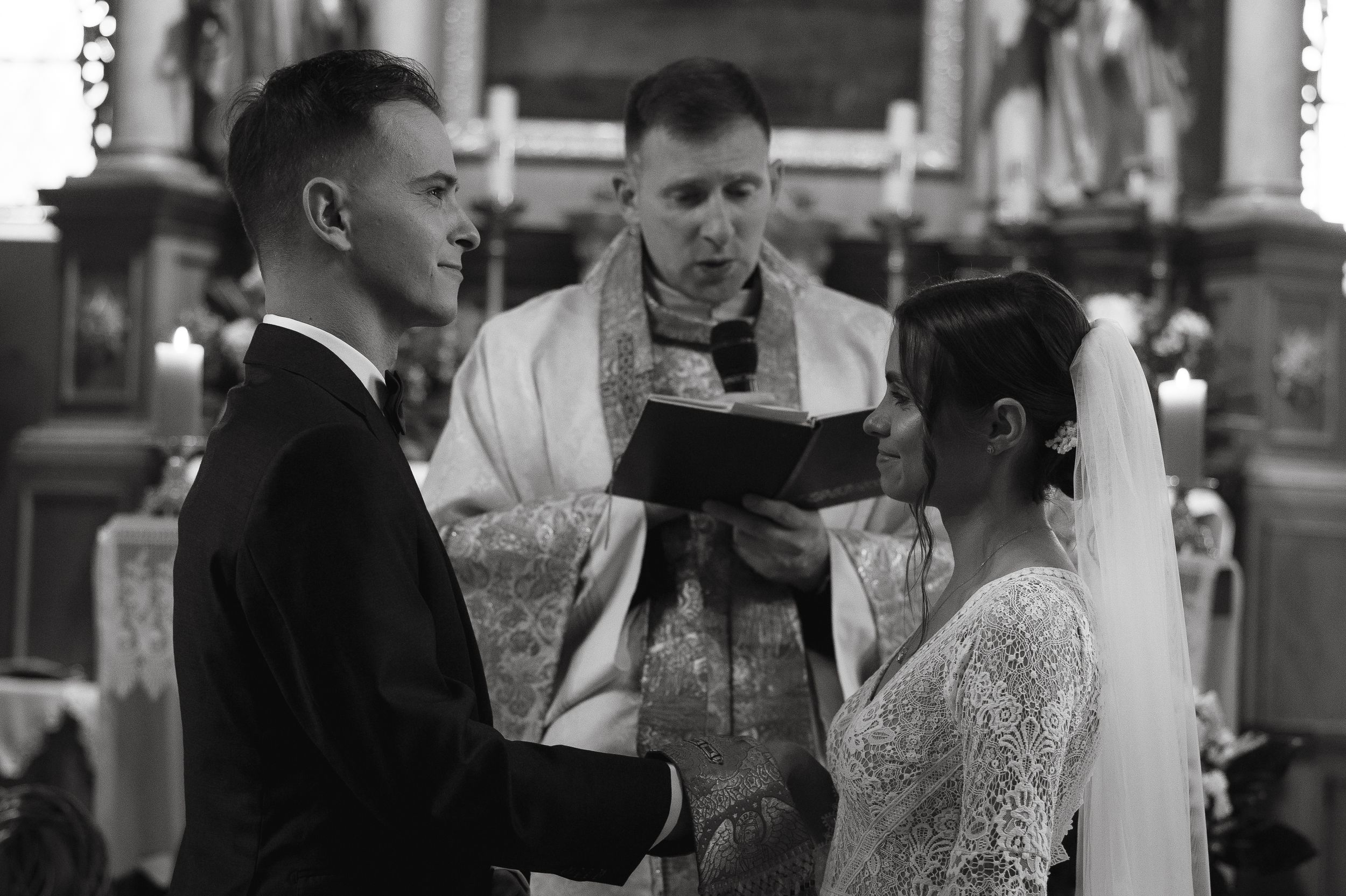 Wedding guests share an emotional moment during a candid monochrome photograph at an elegant reception celebration.