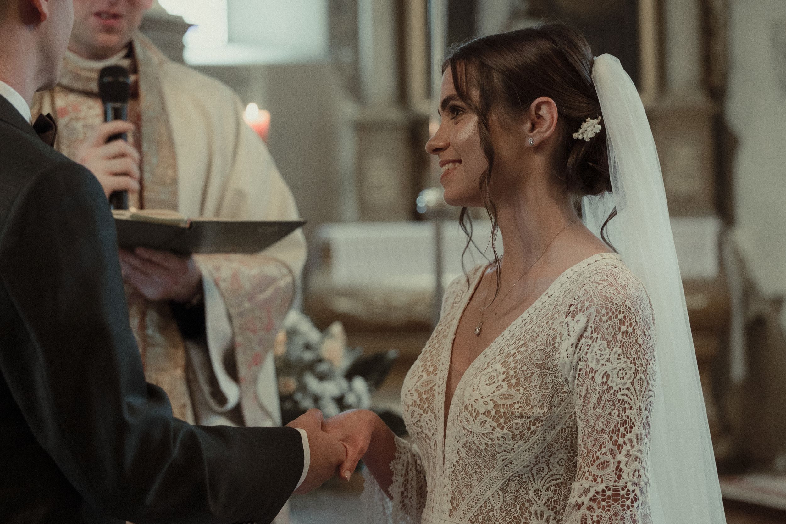 A wedding couple shares an intimate moment together during their ceremony in a historic church setting.