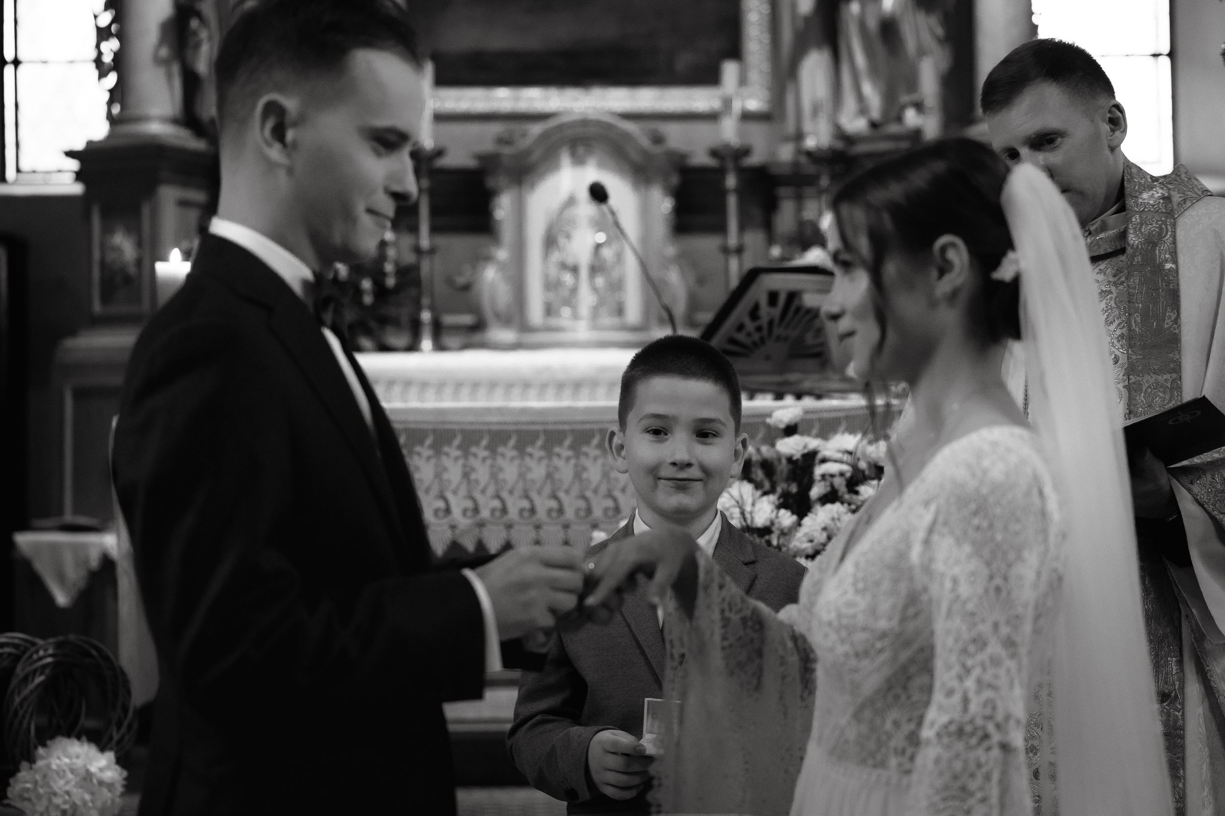 A black and white photo collage showing candid moments from a wedding celebration featuring the couple and guests.