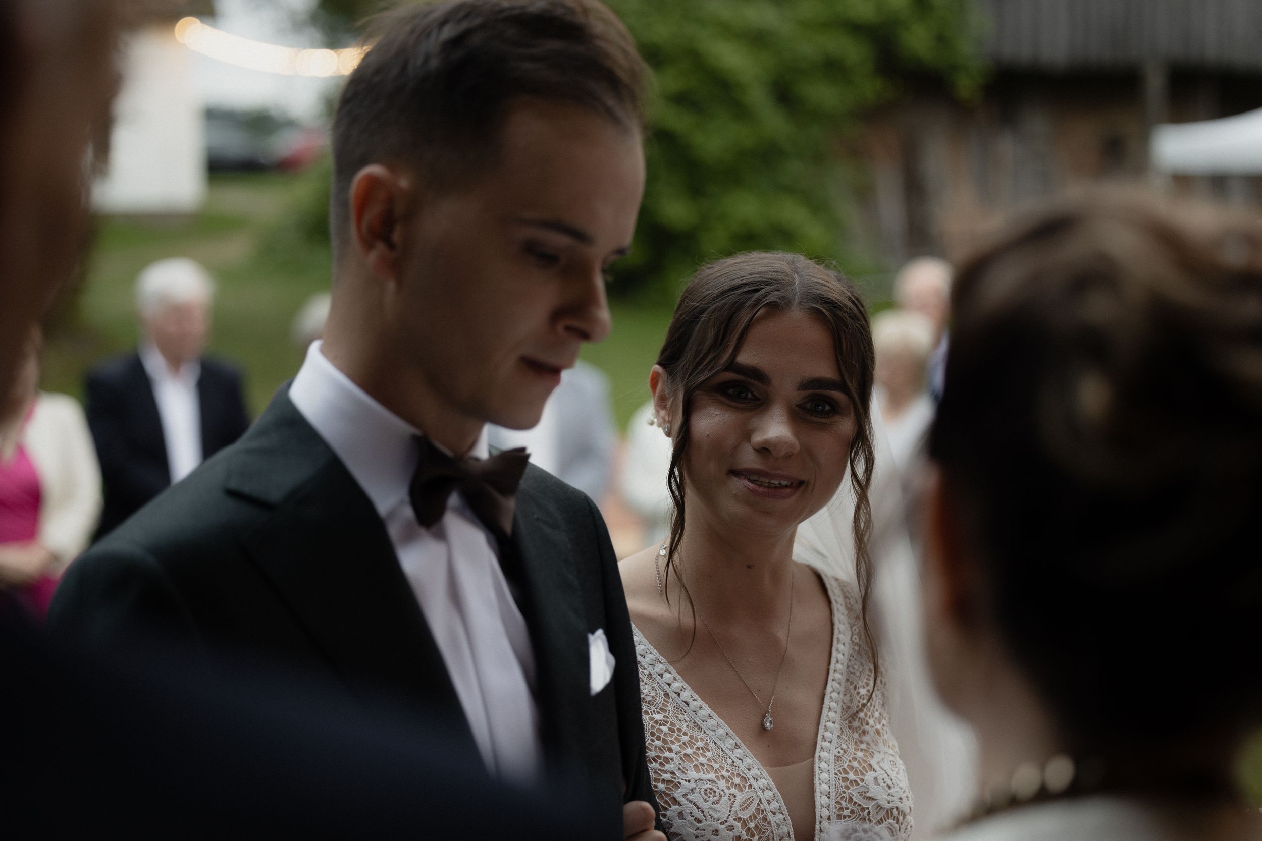 Reception guests celebrate during the first dance at a wedding while elegantly dressed in formal attire.