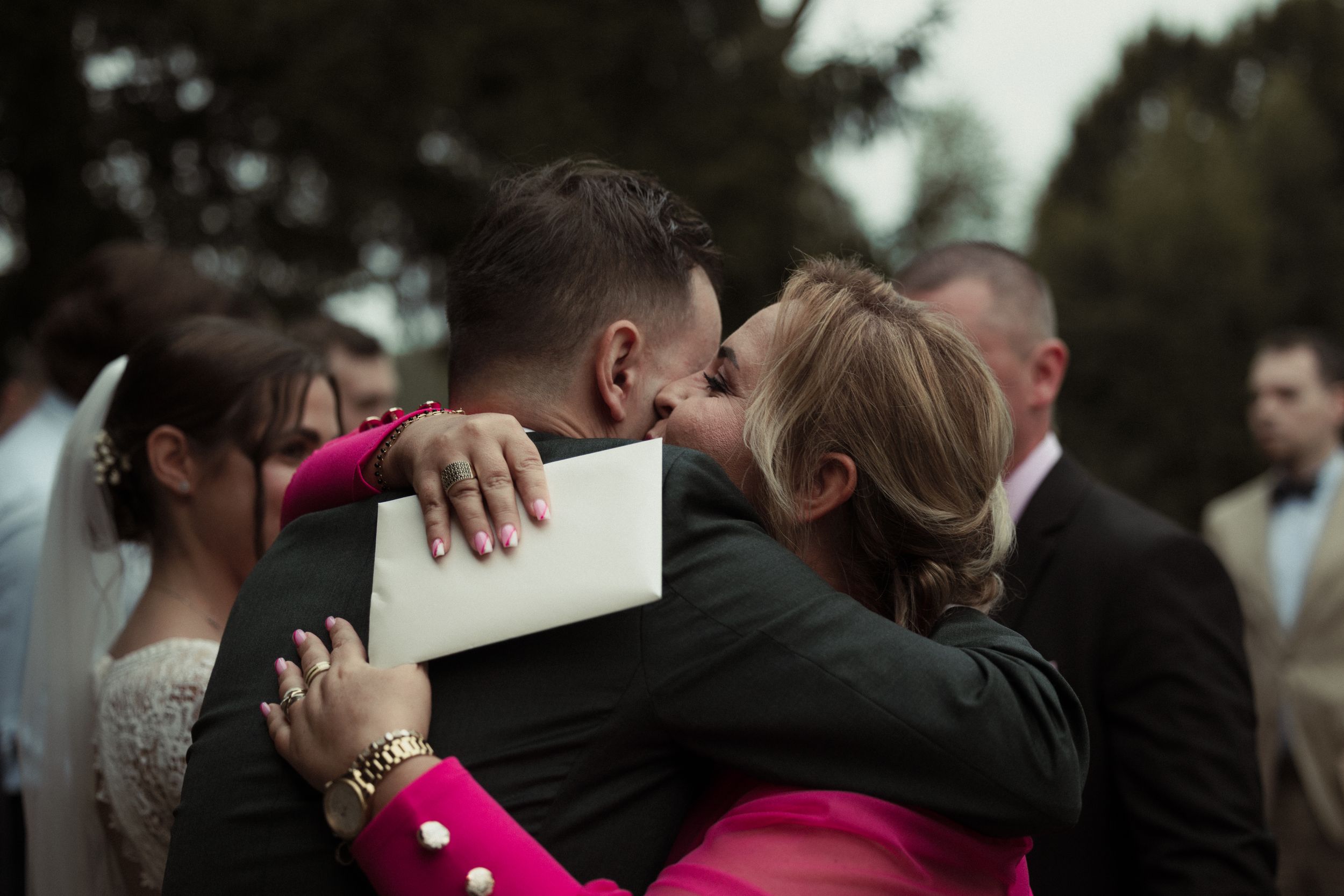 A group of people embrace emotionally during what appears to be a somber gathering or memorial service.