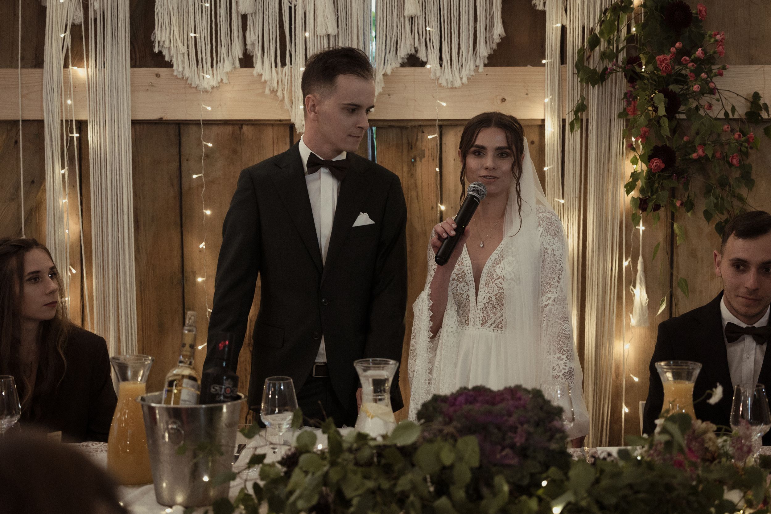 A romantic wedding reception venue with string lights and crystal chandeliers creating an intimate ambiance.