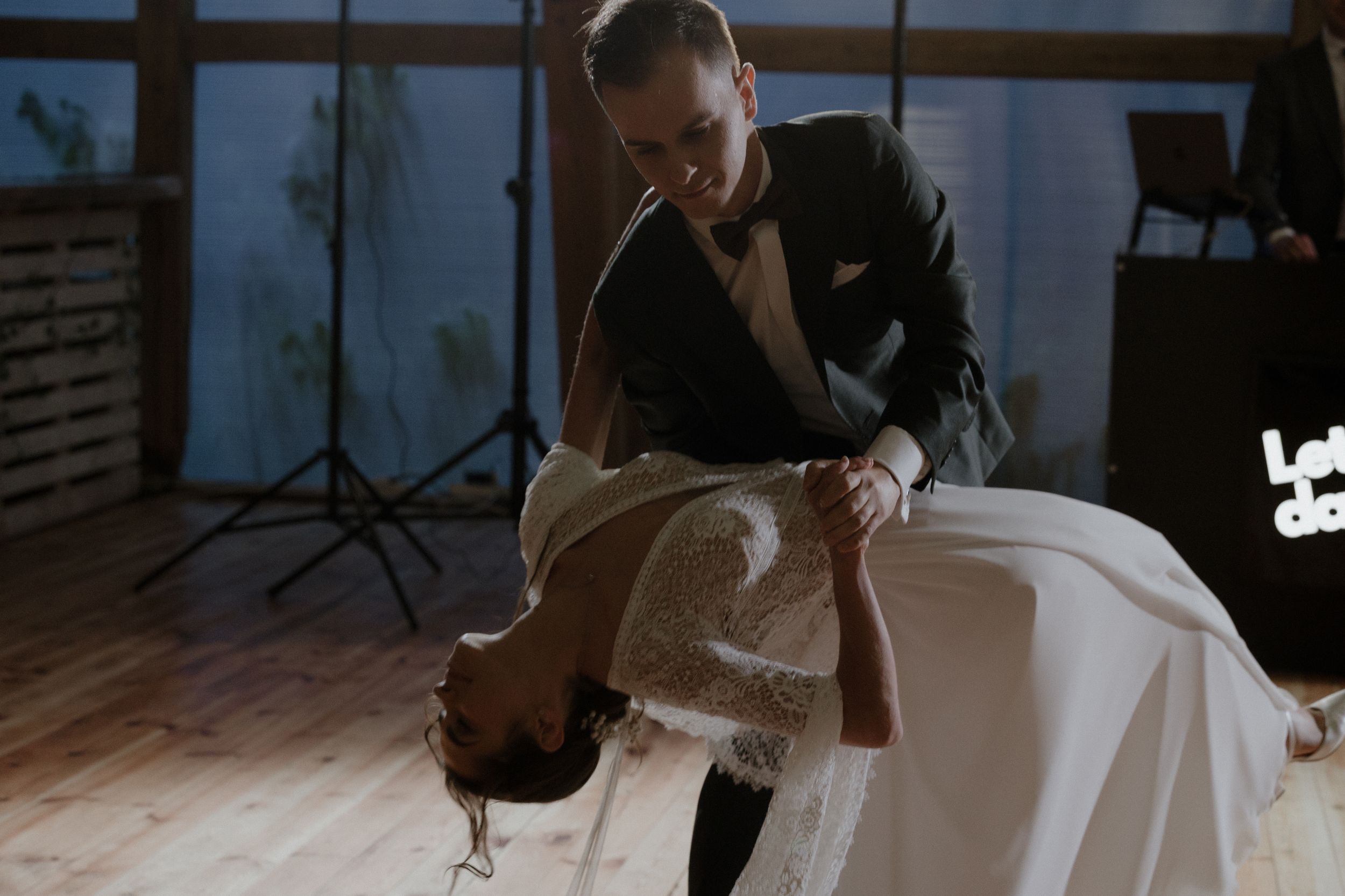 Wedding couple takes their first dance on the ballroom floor surrounded by family and guests for a special moment.