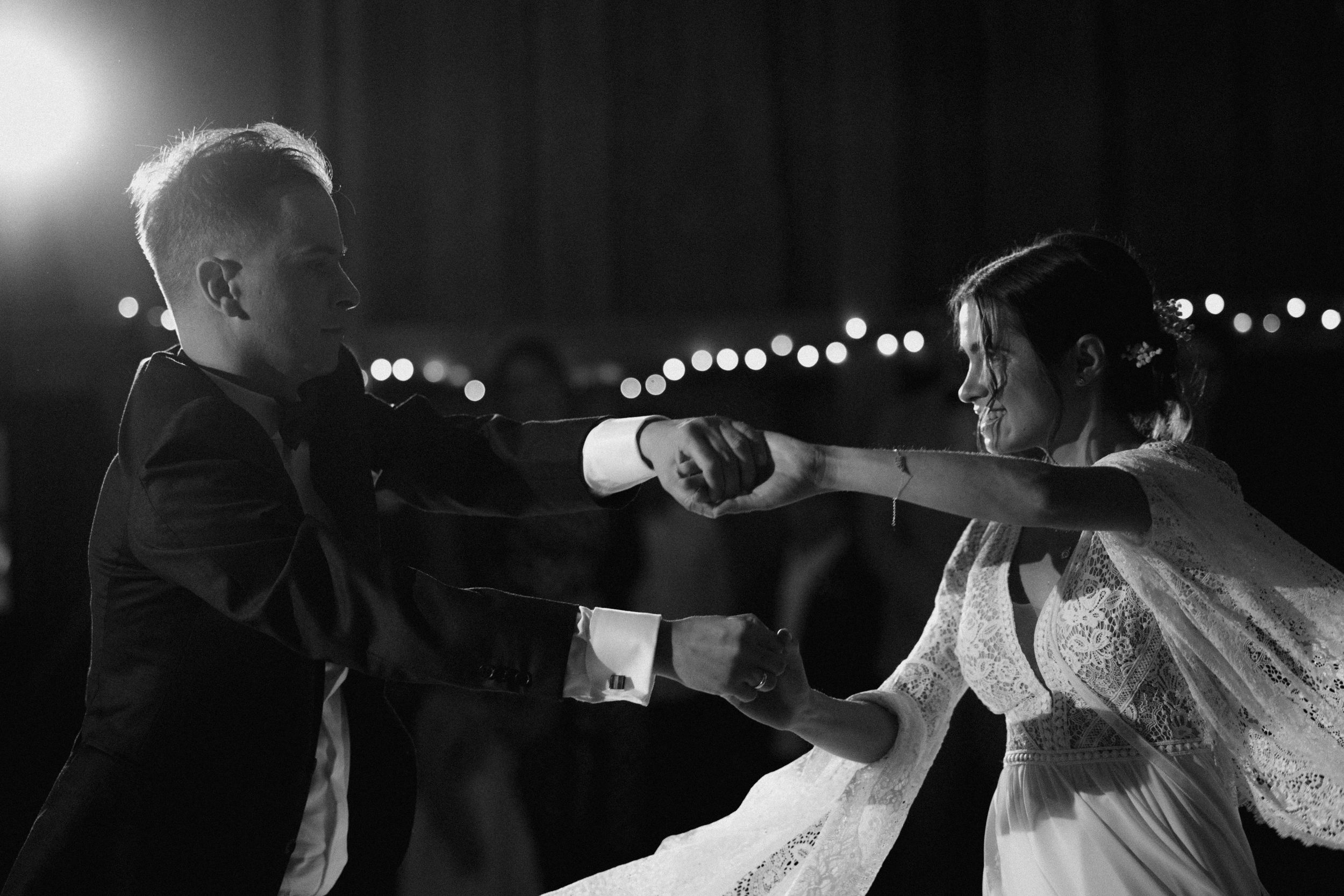 Black and white panoramic sequence showing dancers in elegant dresses moving gracefully during a swing dance performance.