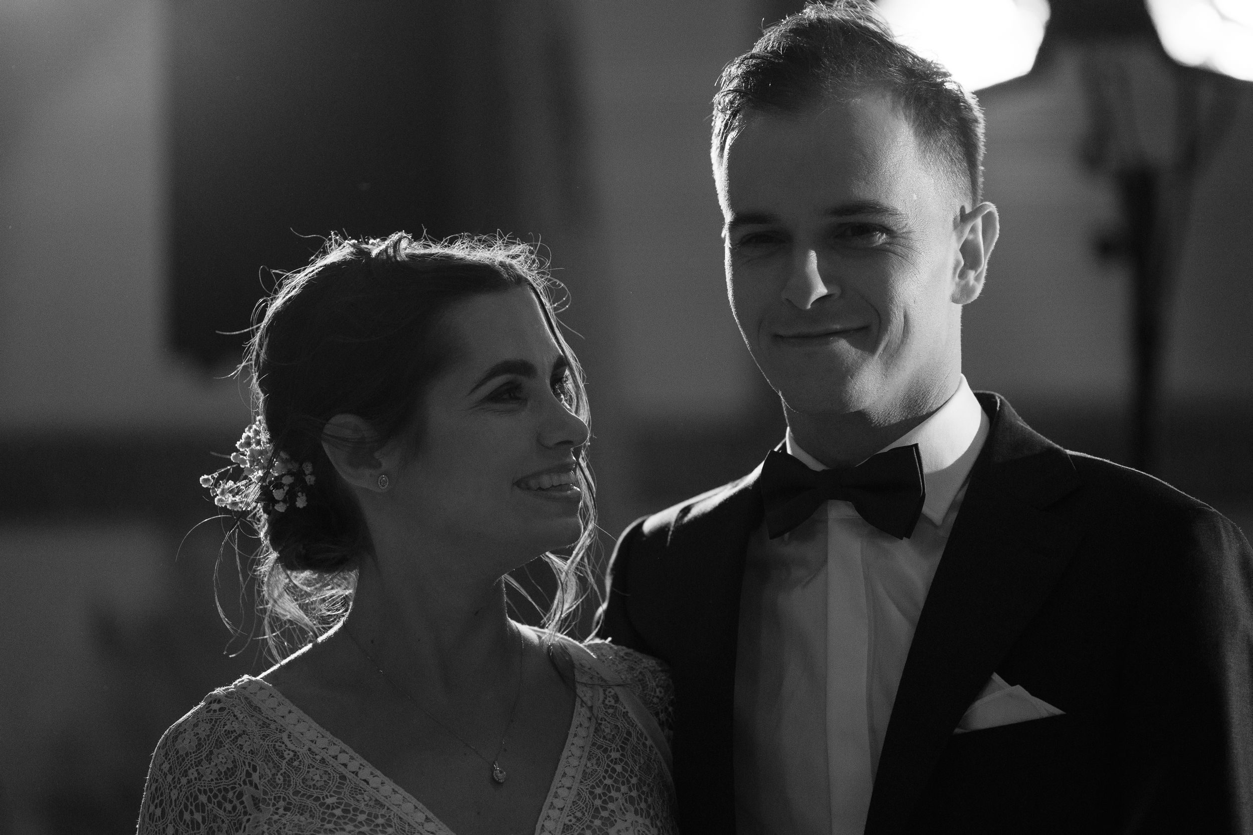 A black and white wedding photo collage showing intimate moments between newlyweds in formal attire.