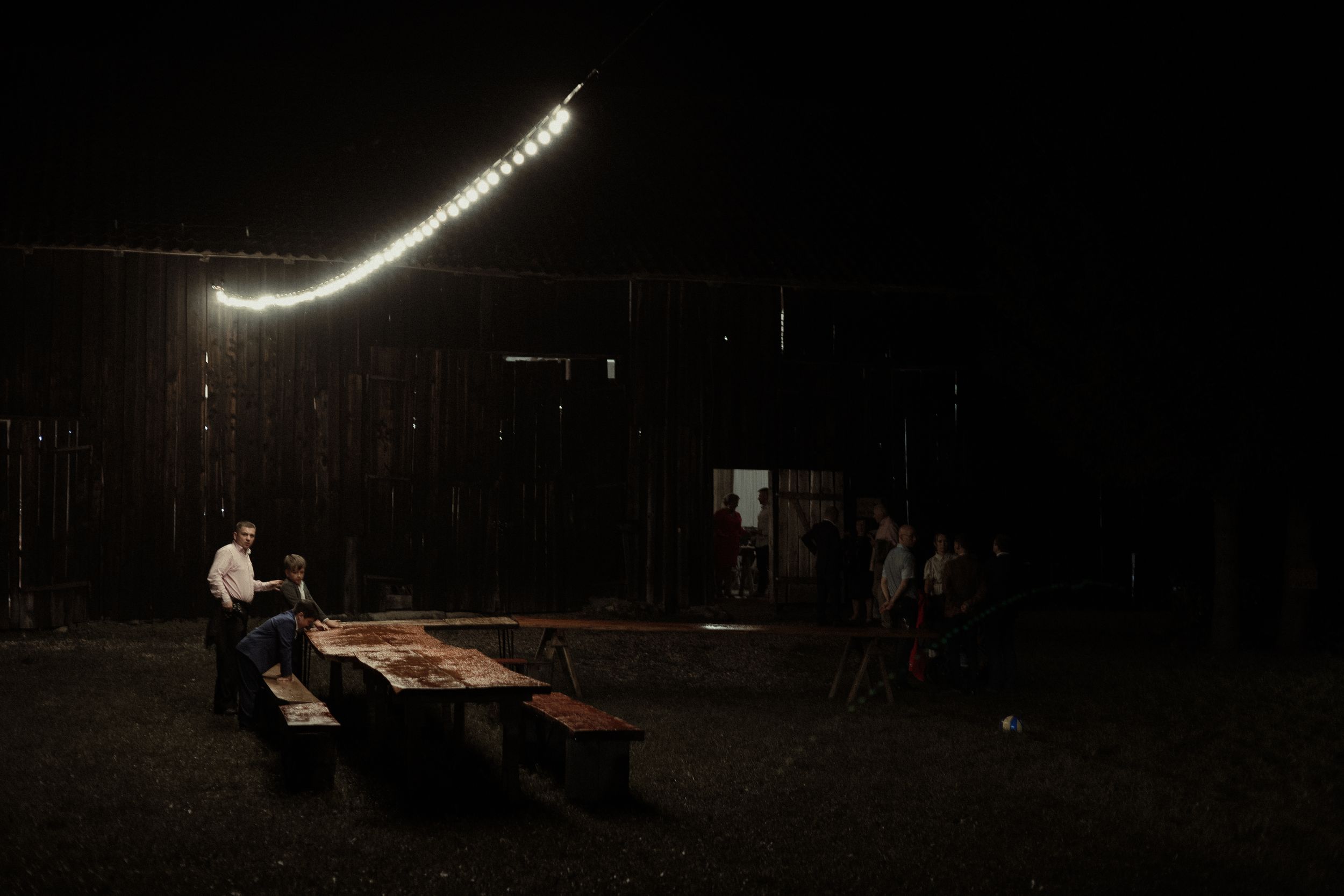 Dark performance stage with dramatic lighting effects and silhouetted figures creating an atmospheric theatrical scene.