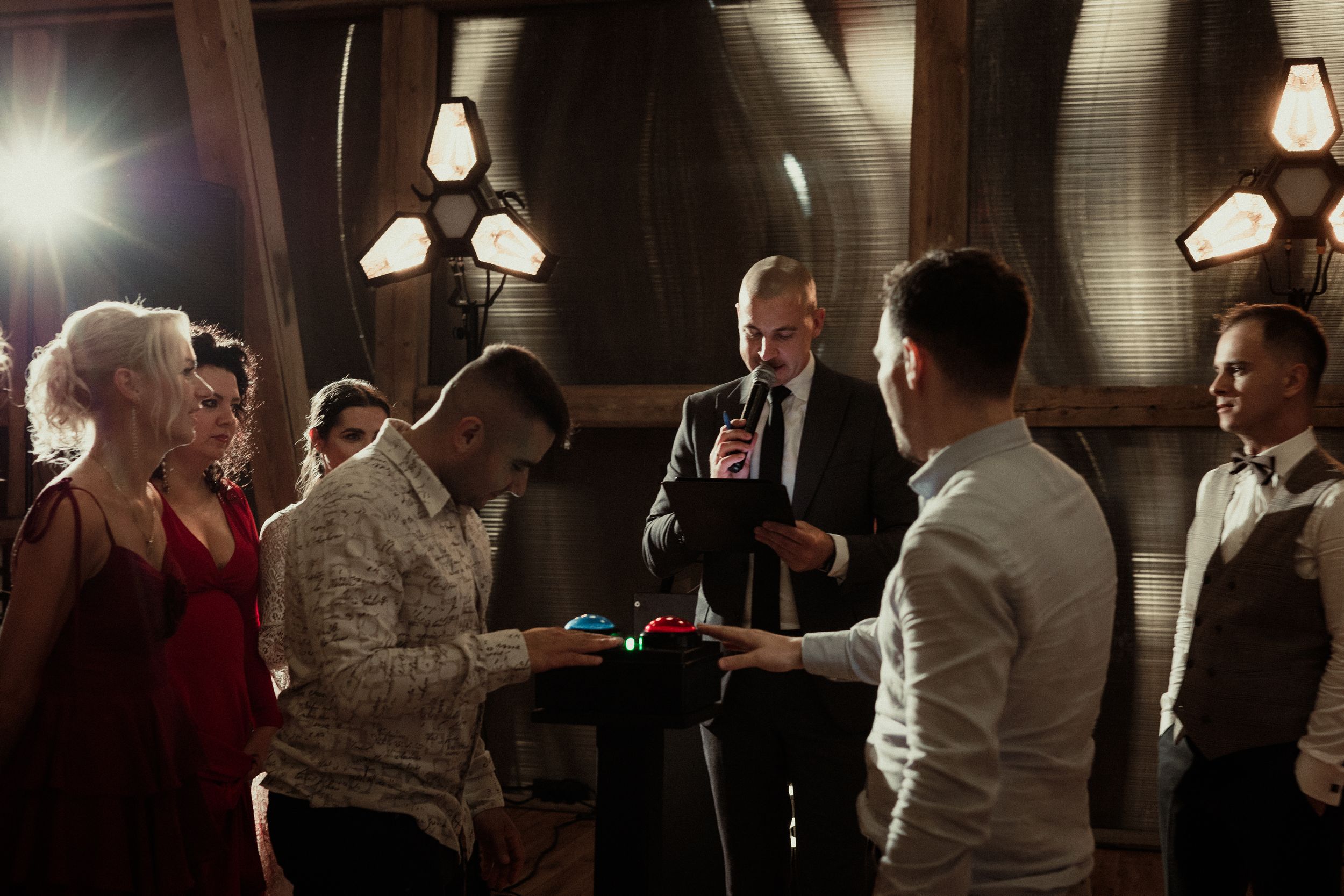 People gathered together in a dimly lit restaurant space having drinks and socializing at an indoor event.