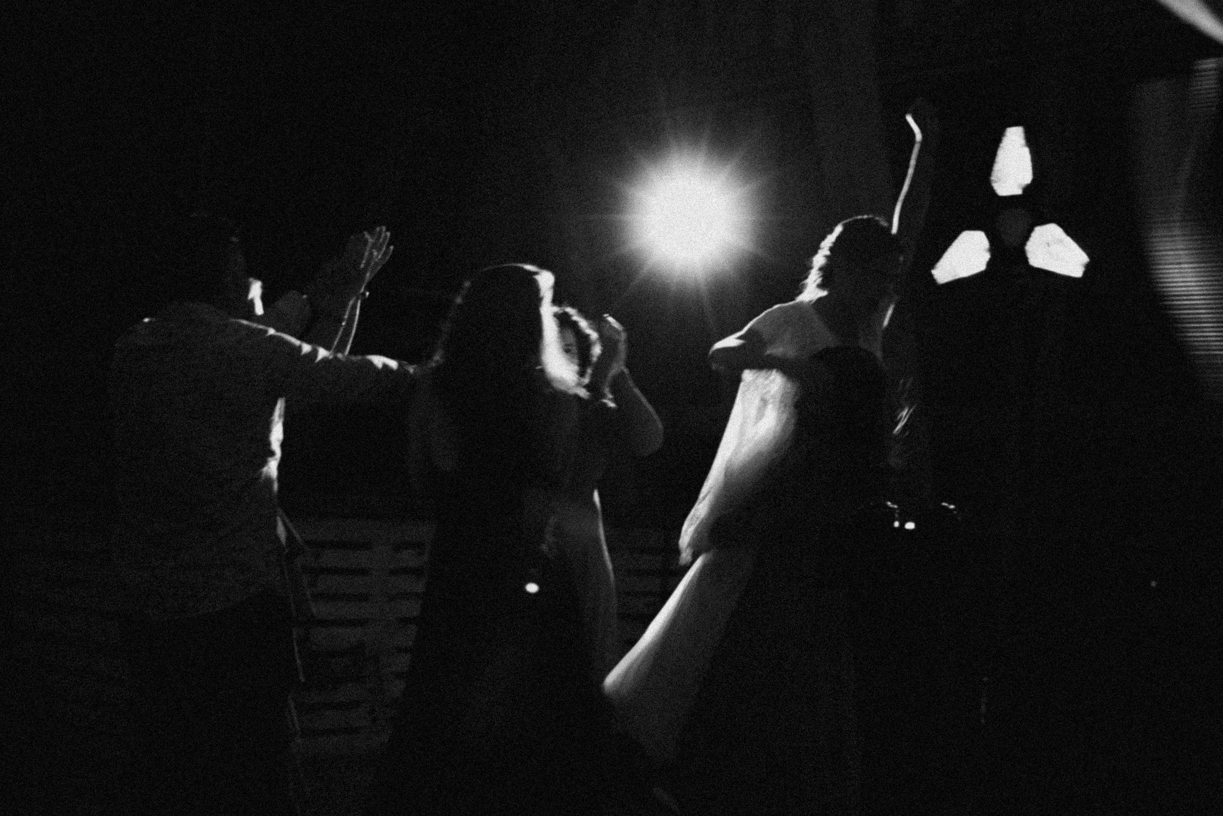 Dramatic black and white photo series shows silhouettes of musicians performing on stage under spotlights.