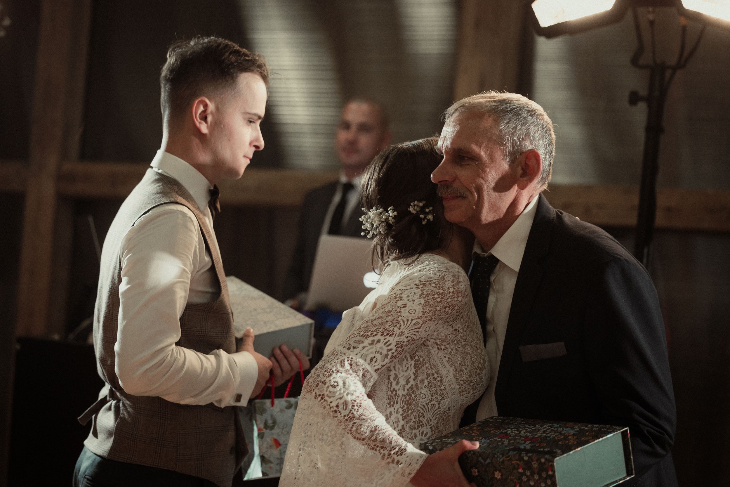 A couple shares an intimate dance at a wedding reception on a softly lit dance floor.