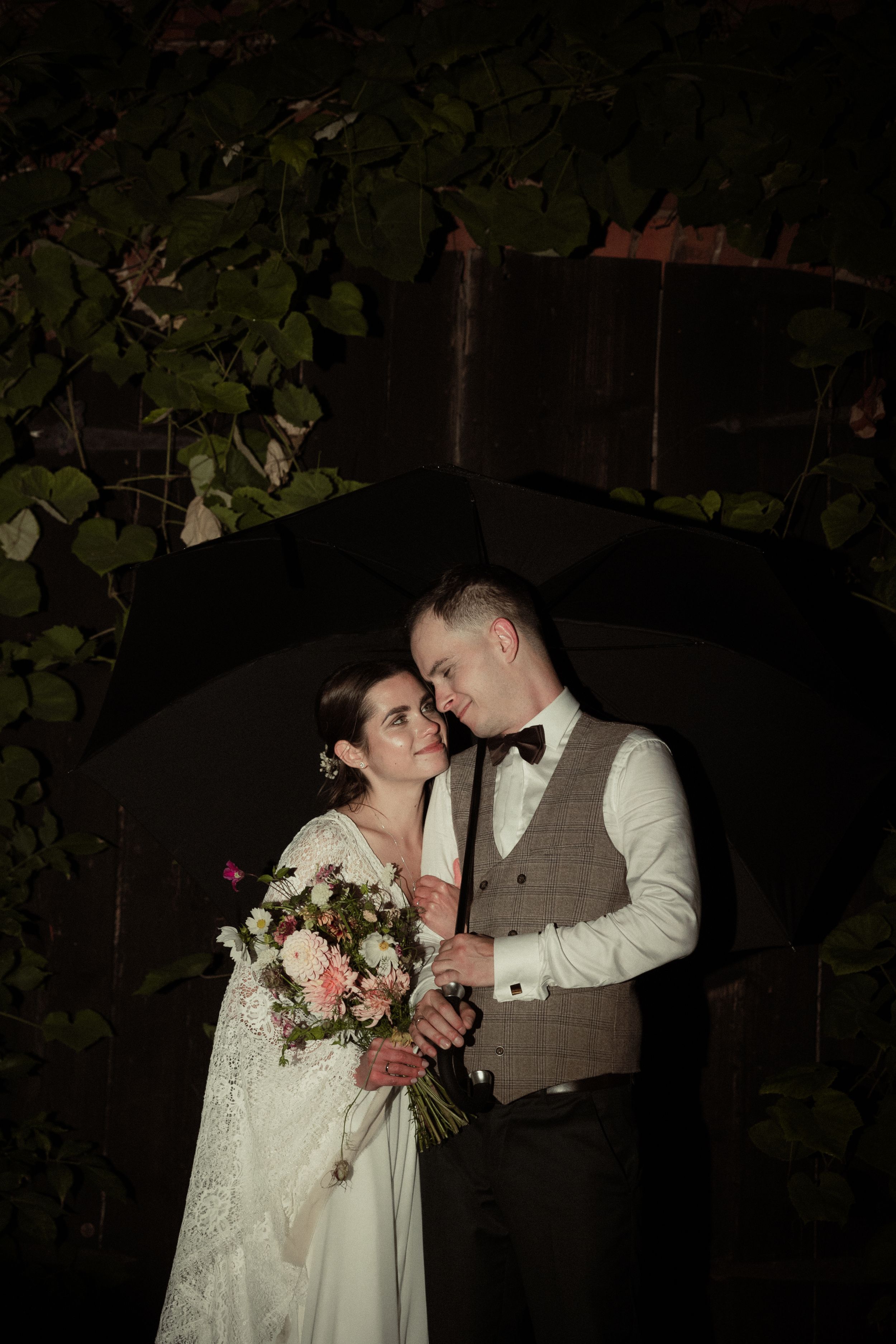 Romantic wedding couple share intimate moments in a garden setting with soft lighting and floral decor.