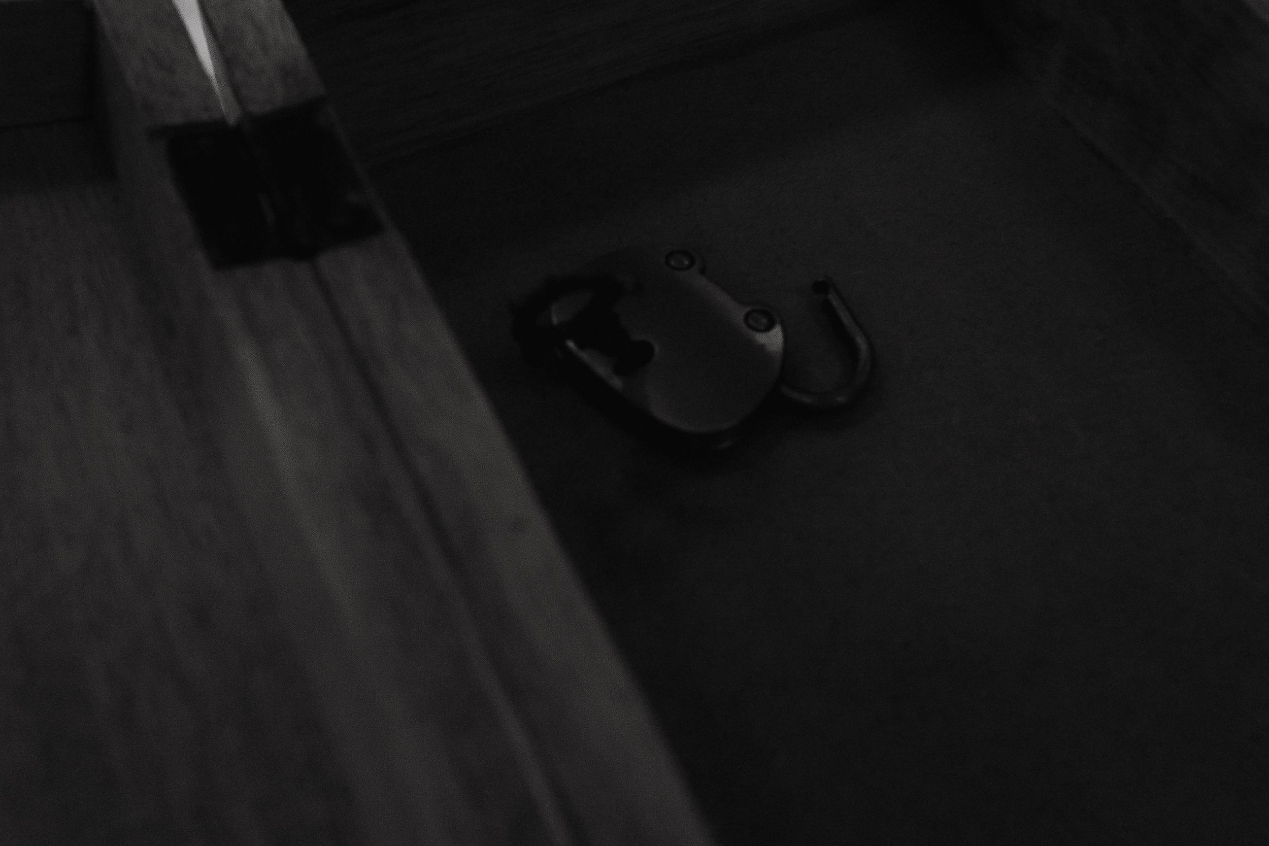A dark monochrome wedding photograph shows a couple facing each other on their special day through a filtered lens.