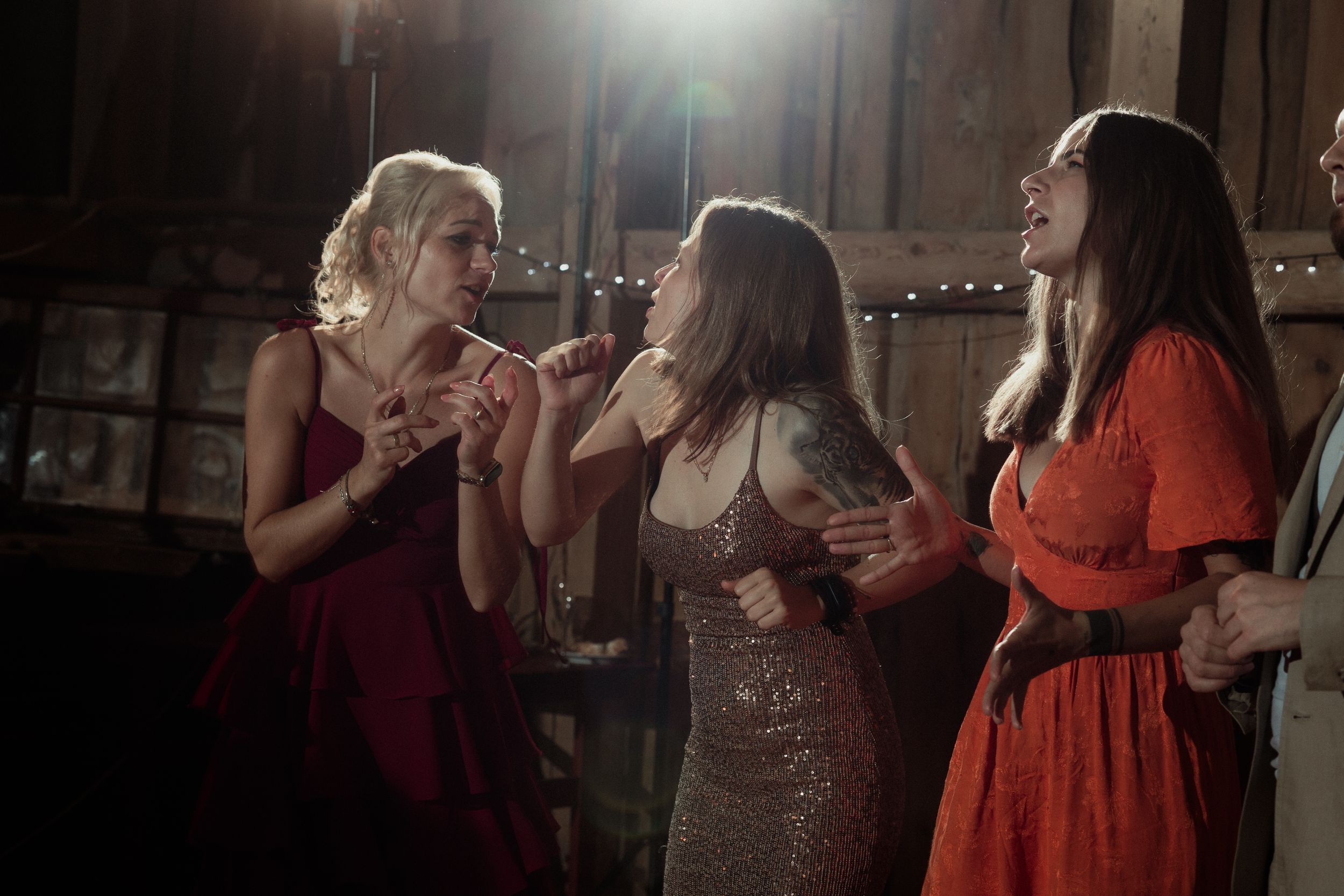 People dancing and celebrating together on a dimly lit dance floor at a festive party event.