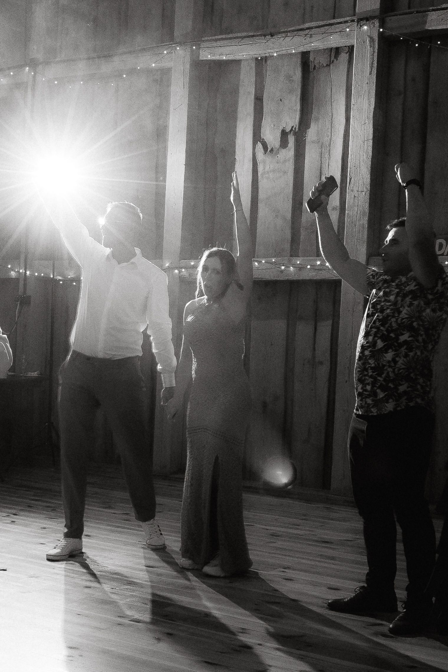 A sequence of four black and white photos showing feet dancing and casting dramatic shadows on a wooden dance floor.