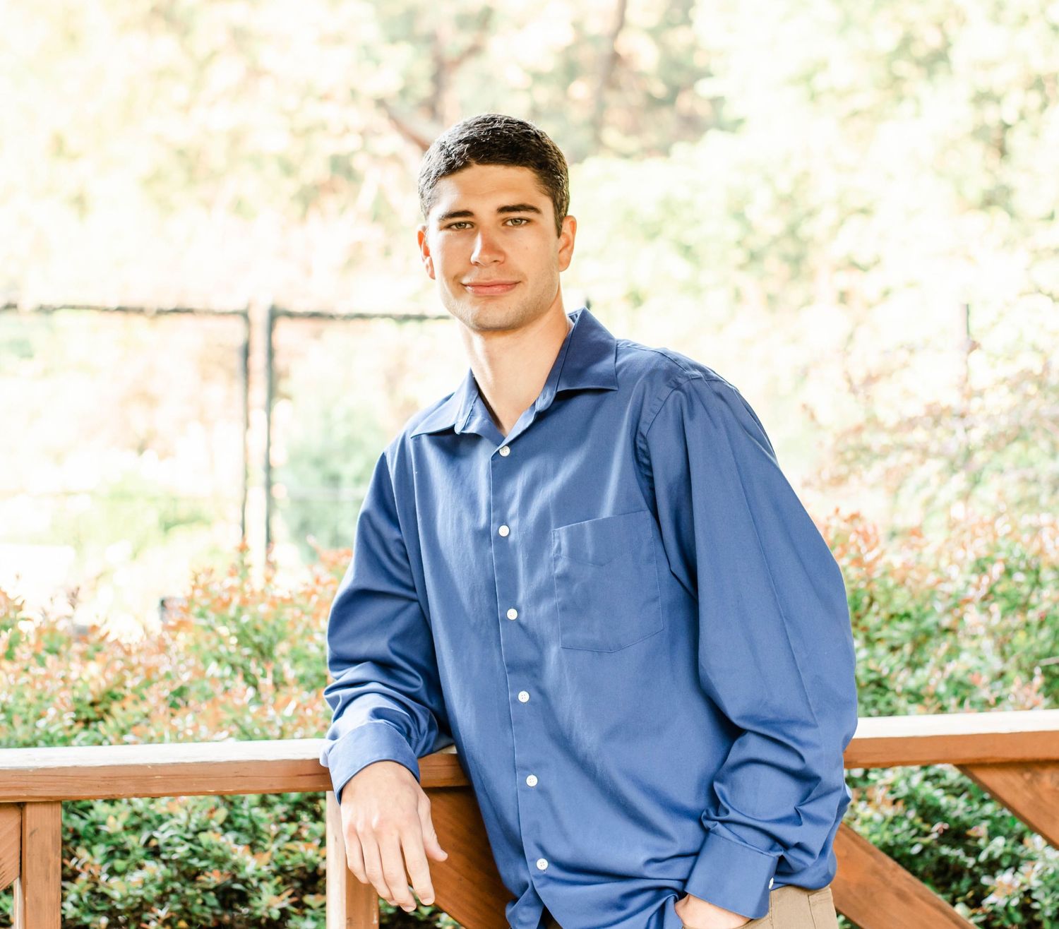 Outdoor portraits featuring someone in a blue collared shirt against wooden railings.