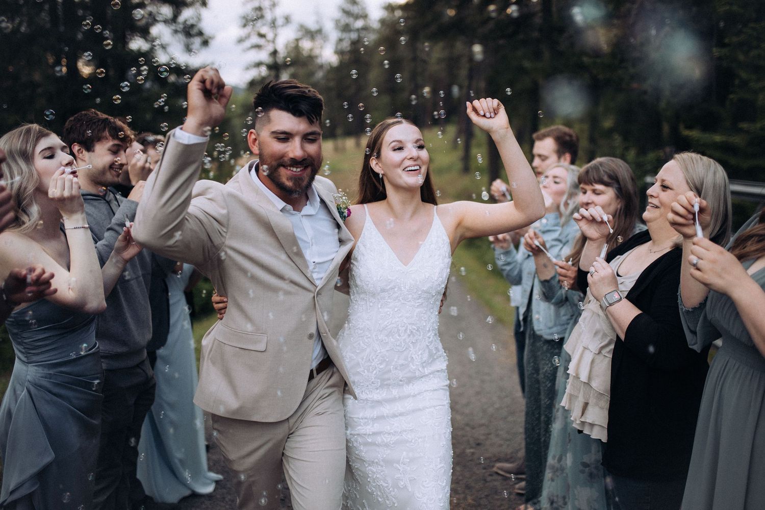 Bride and groom walking through bubbles during their wedding exit in Idaho
