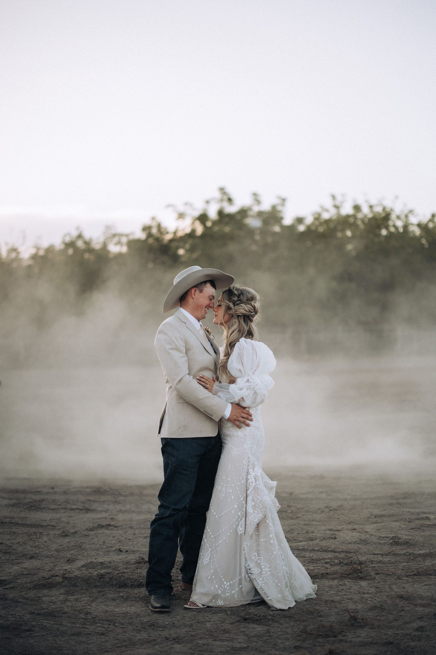 Country bride and groom celebrating their rustic California wedding in a rodeo arena