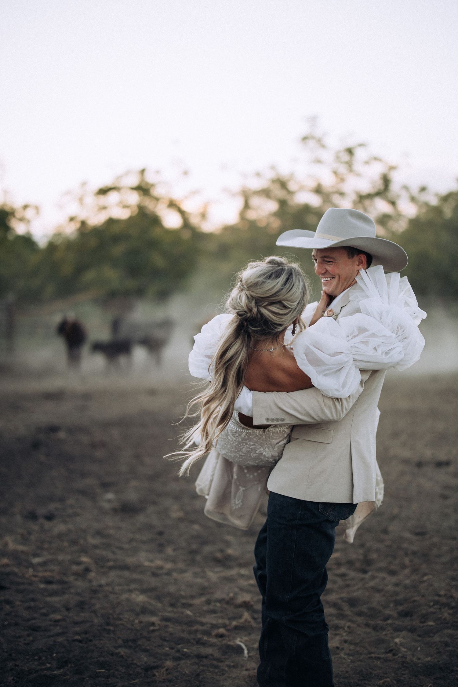 Country bride and groom celebrating their rustic Idaho wedding in a rodeo arena